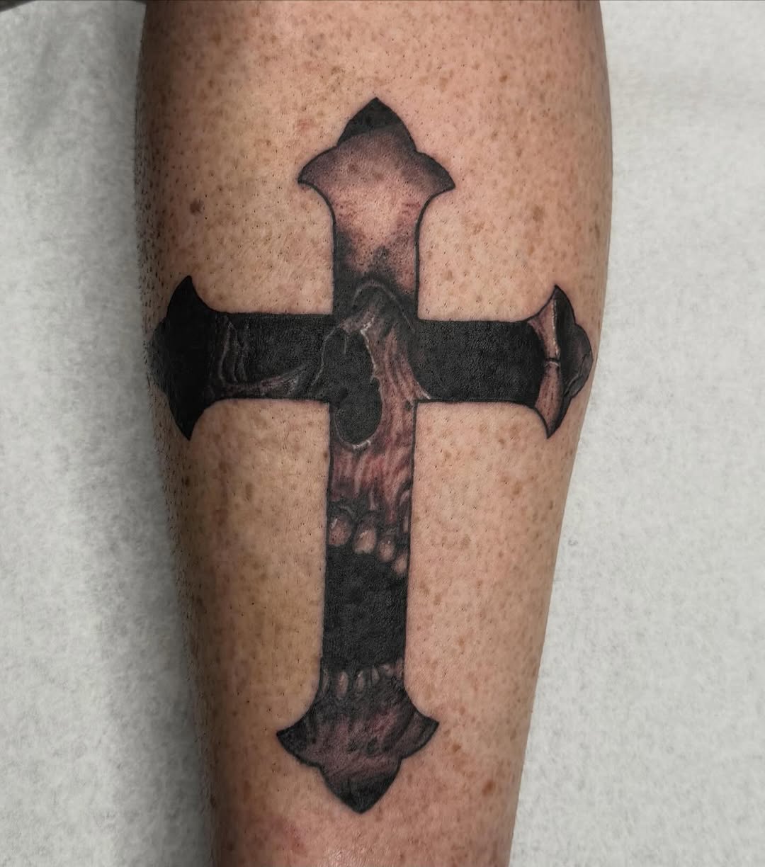Cross with skull elements realism tattoo on the forearm by savannah