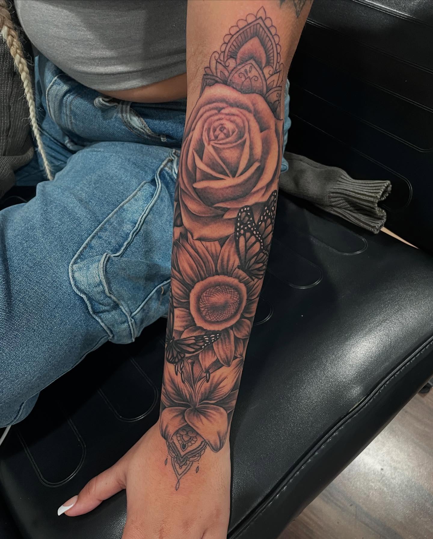 Flowers and butterfly realism tattoo on the forearm by Blake