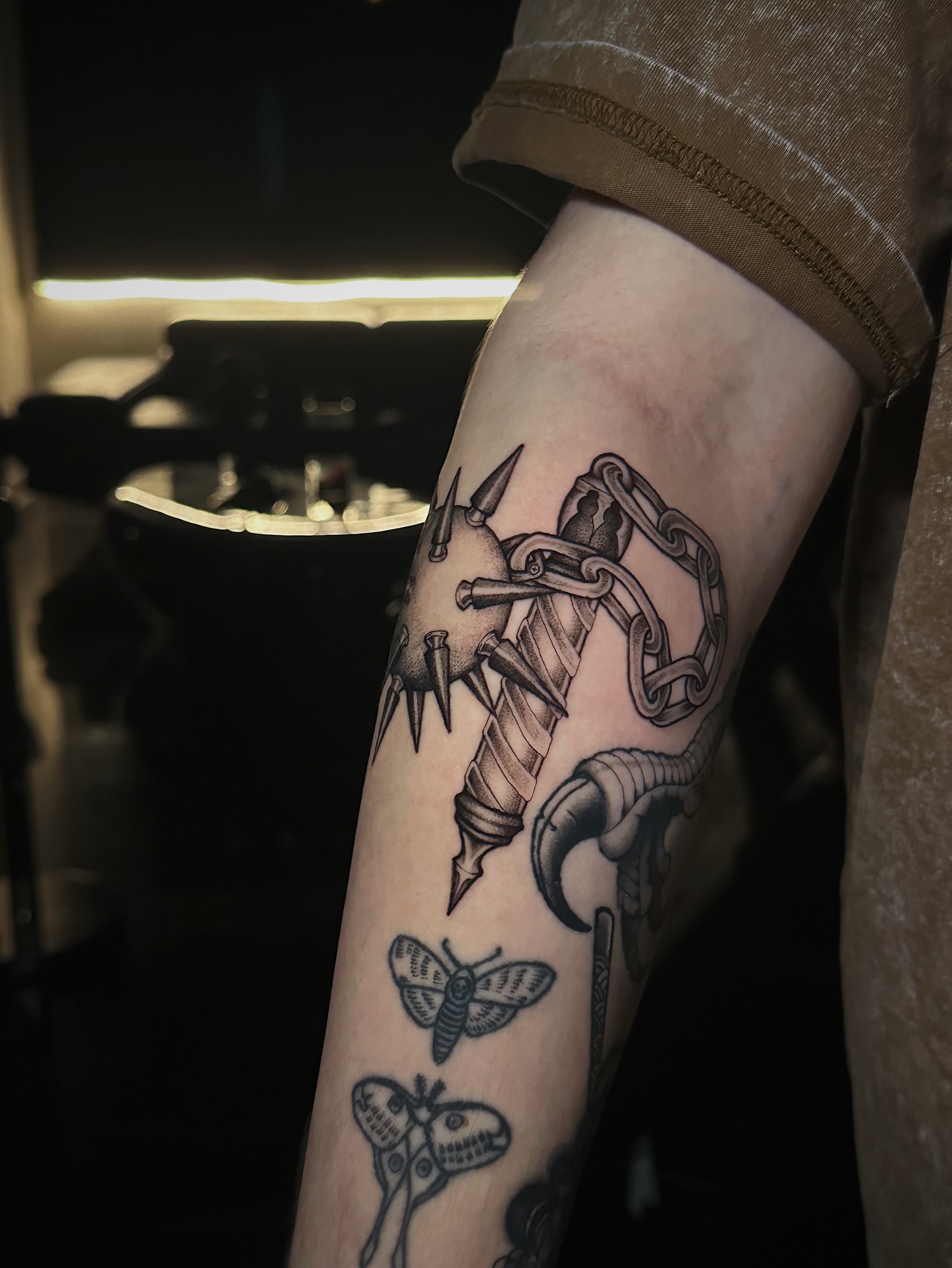 Tattoo machine and moth black and grey tattoo on the forearm by Kelsey Zussman