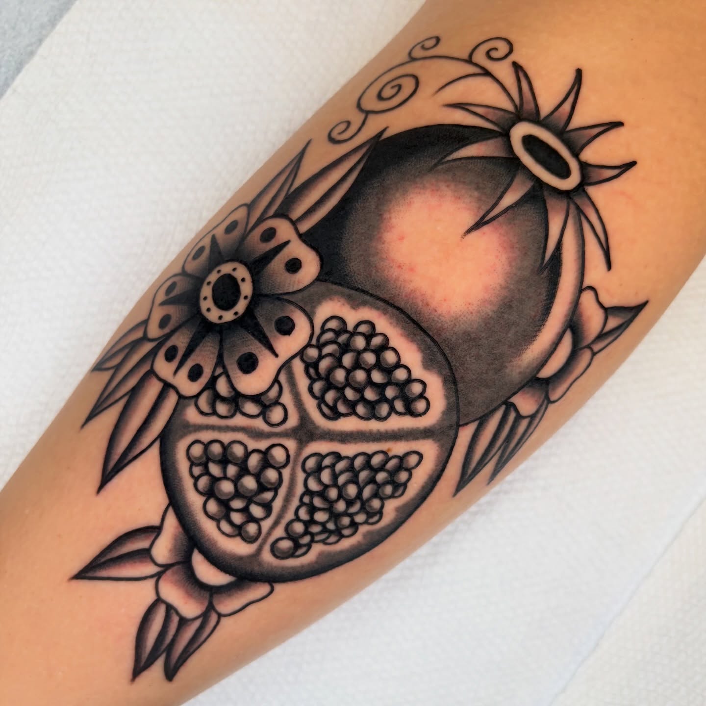 Pomegranate black and grey tattoo on the forearm by rachael