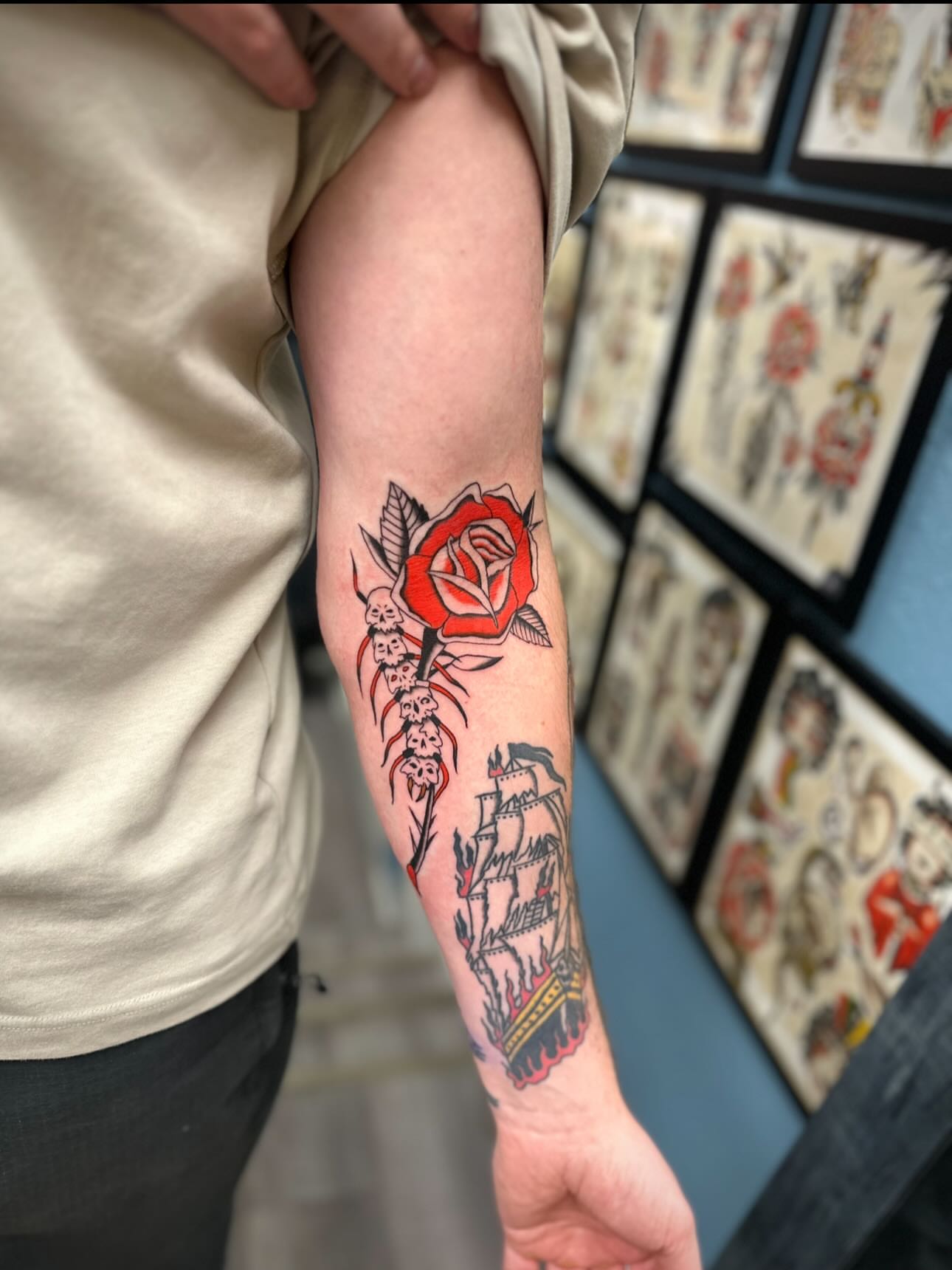 Red rose with ship and skulls American traditional tattoo on the forearm by rory