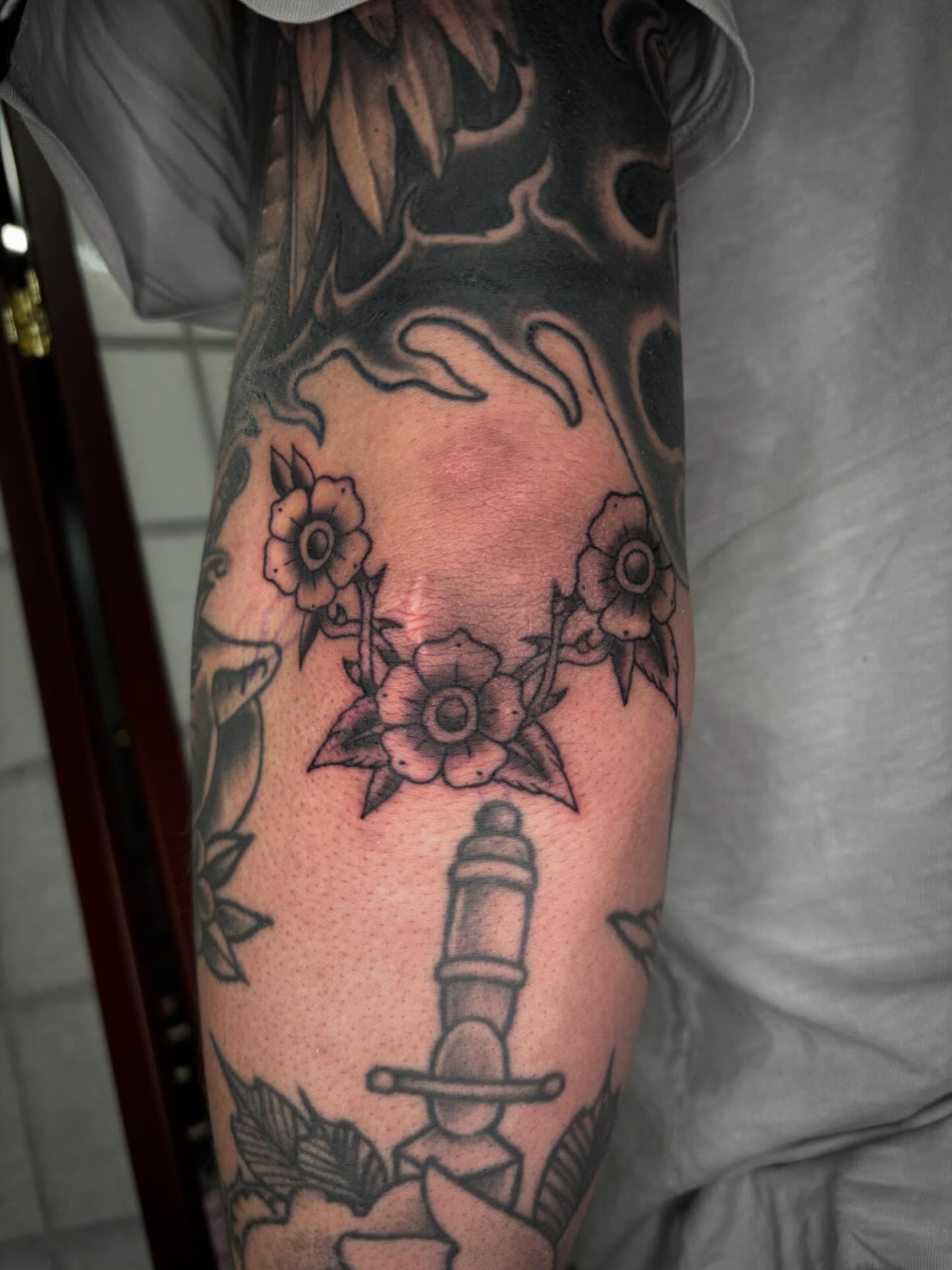 Sword and flowers American traditional tattoo on the forearm by Brett Ferguson