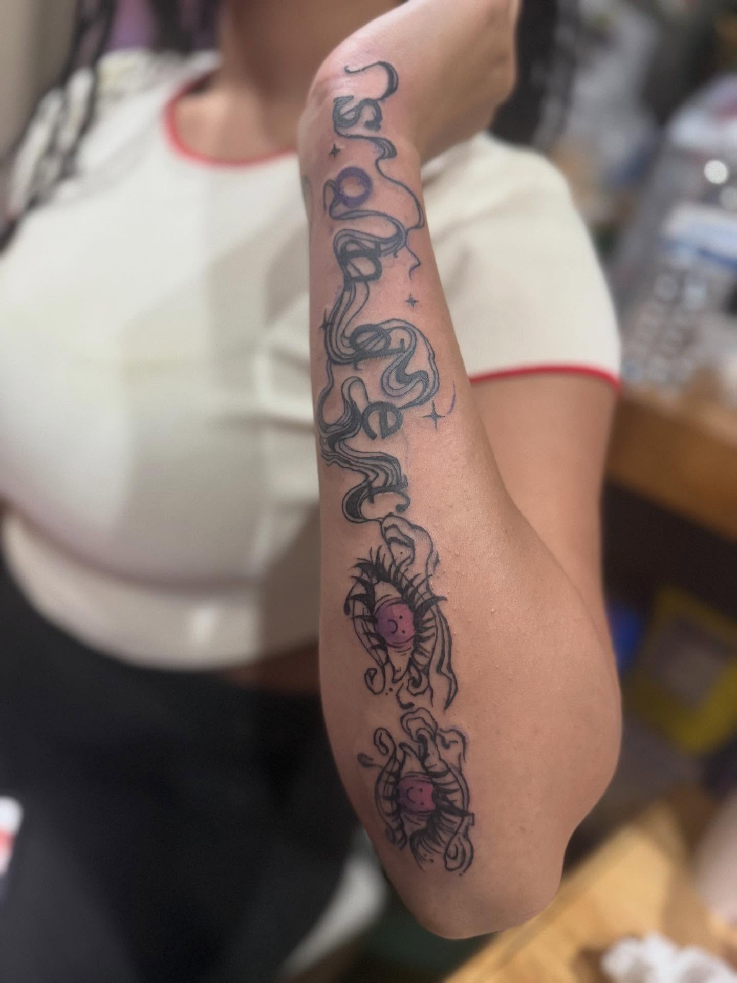 Serpent and celestial body black and grey tattoo on the forearm by Aja Marie