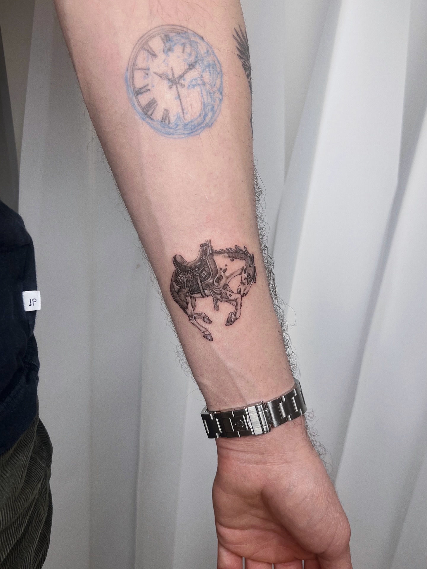 Clock and horse black and grey tattoo on the forearm by Soy 🫛
