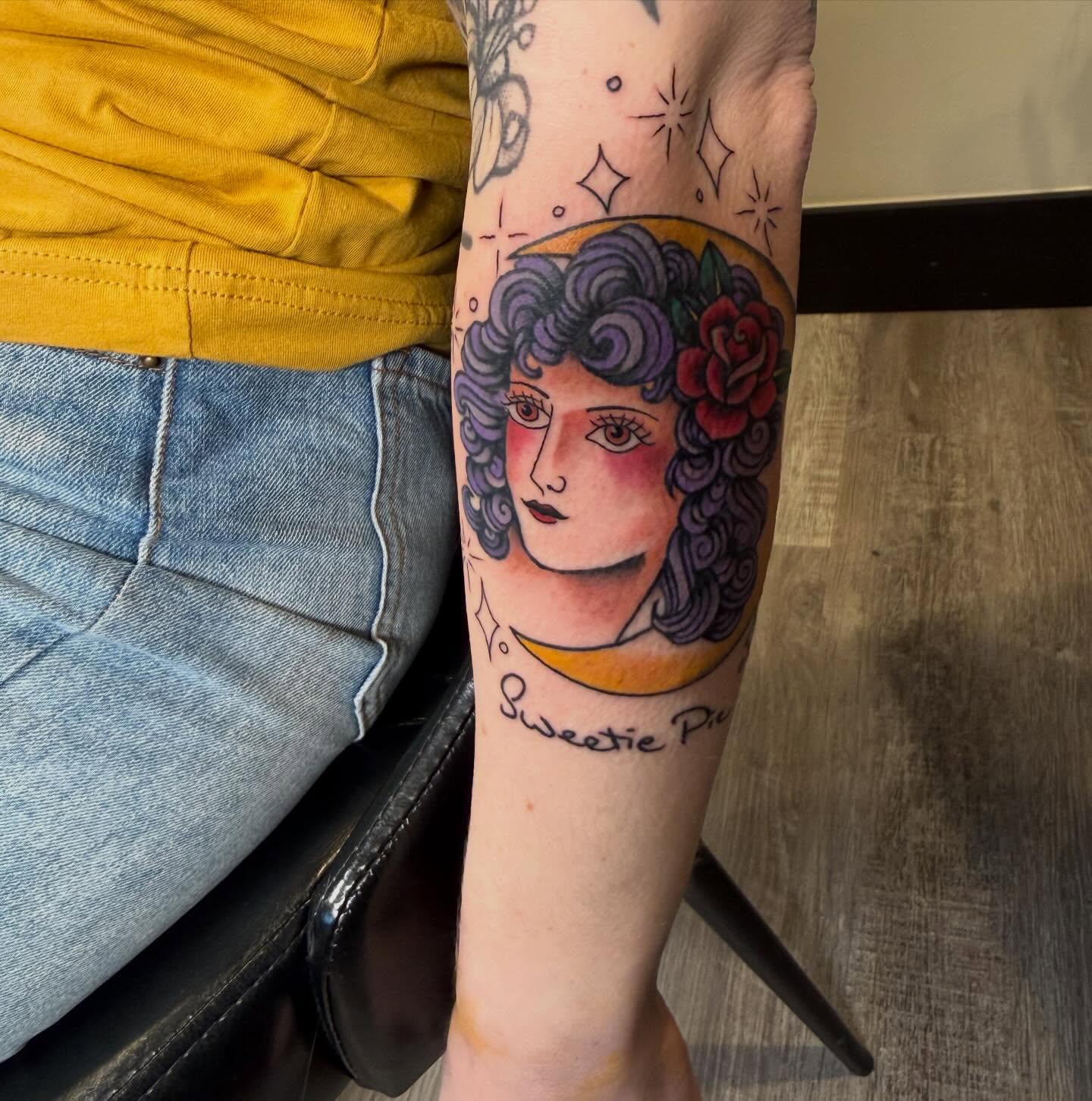 Woman with curly hair illustrative tattoo on the forearm by Rebecca Basma Smith