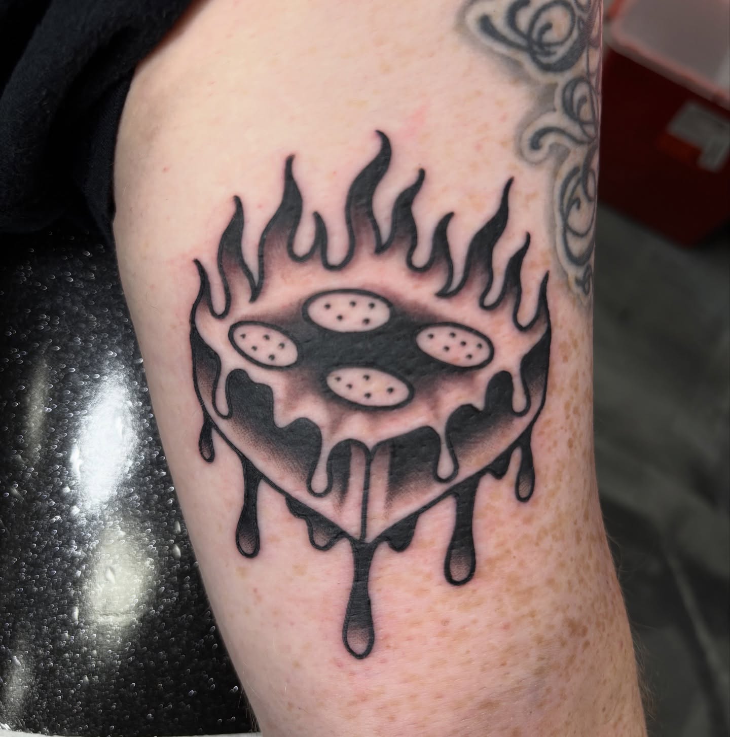 Flaming cookie black and grey tattoo on the forearm by @koma_tk
