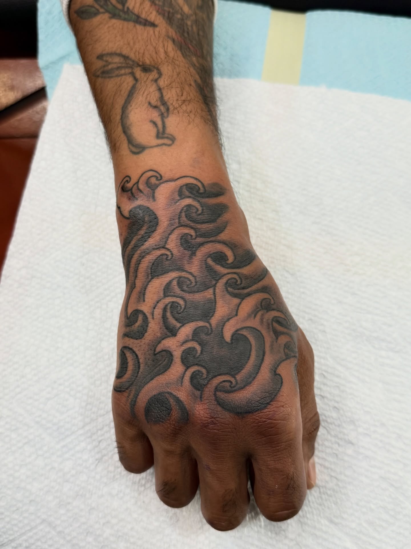 Waves black and grey tattoo on the hand by Andre Guerra