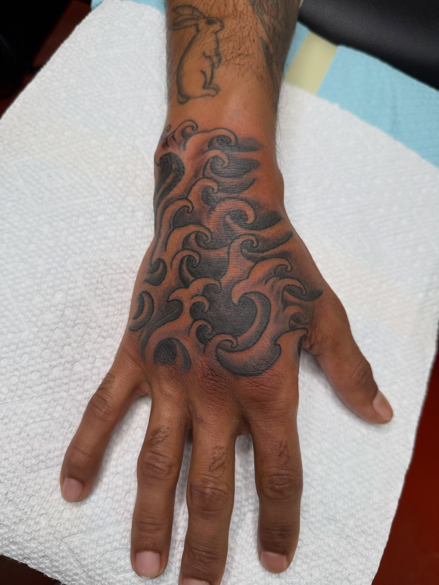 Waves black and grey tattoo on the hand by Andre Guerra