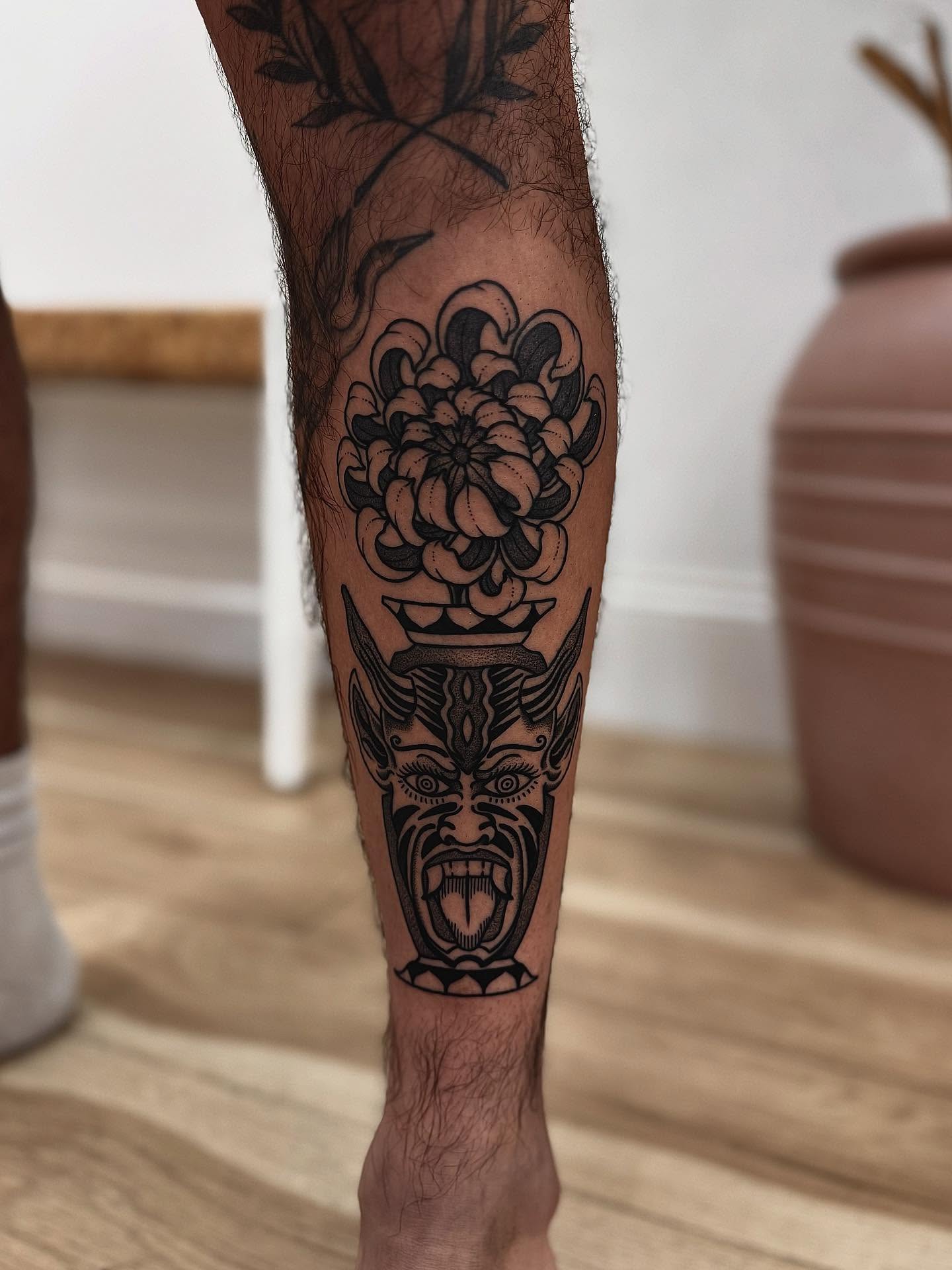 Floral mask black and grey tattoo on the forearm by Stefany