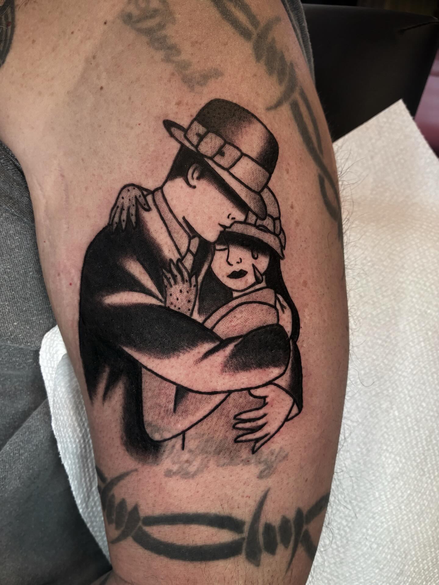 Man hugging child American traditional tattoo on the forearm by ๐๐ช๐๐ซ๐ก๐ ๐๐ฏ๐ถ๐ฉ๐