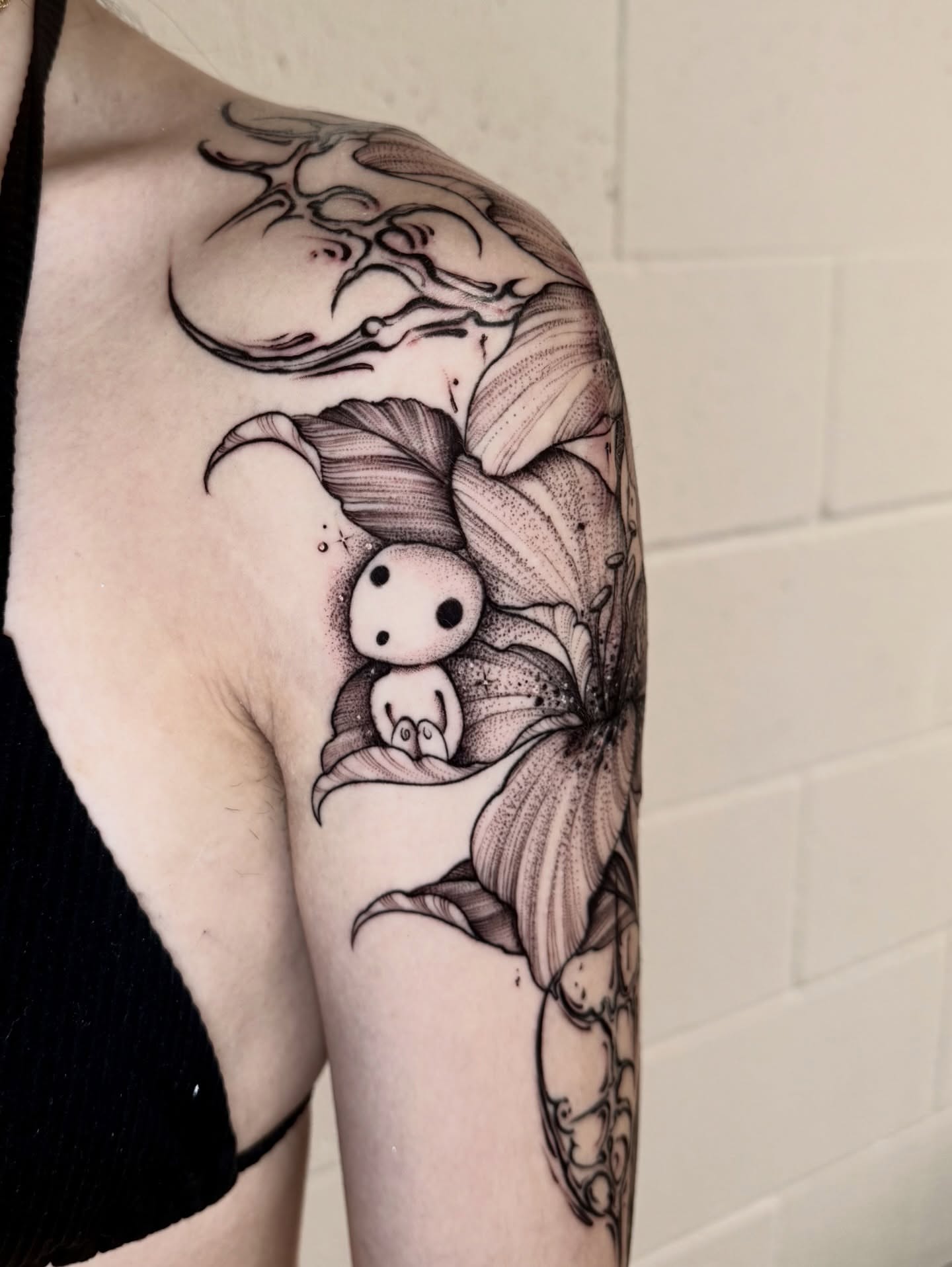 Lily and creature dotwork tattoo on the upper arm by ℳ𝒾𝓇𝓉𝒽𝒶 𝒯ℴ𝓇𝓇ℯ𝓈, San Diego, California