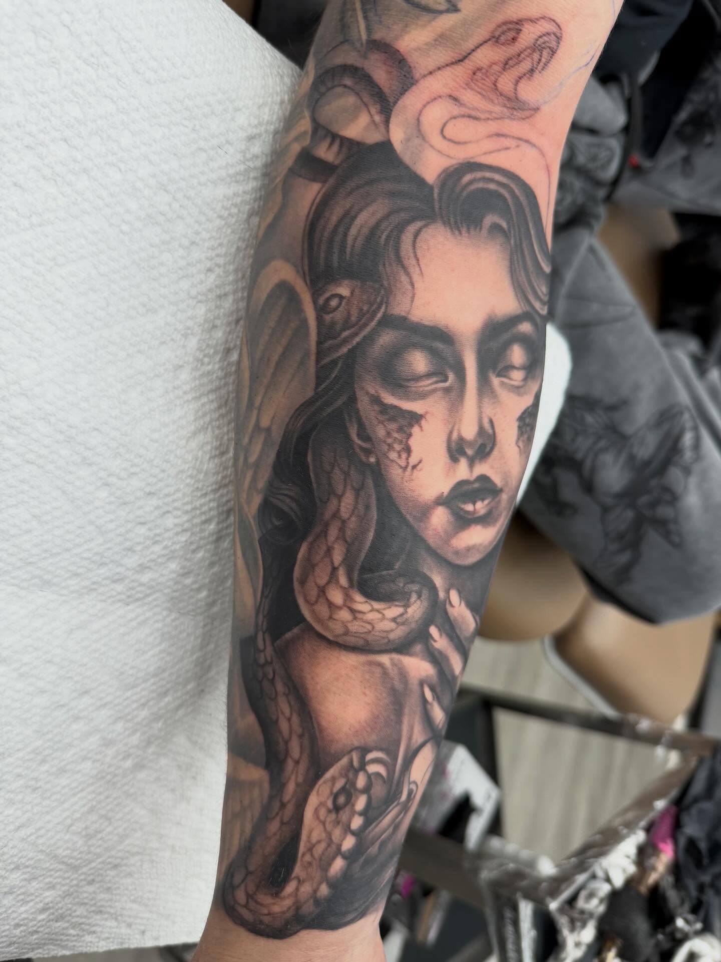 Woman with snakes realism tattoo on the forearm by Denver Tattoo Artist
