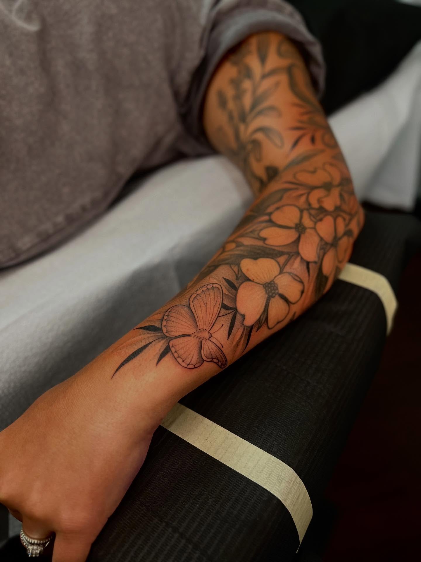 Flowers black and grey tattoo on the forearm by Avrey Simone