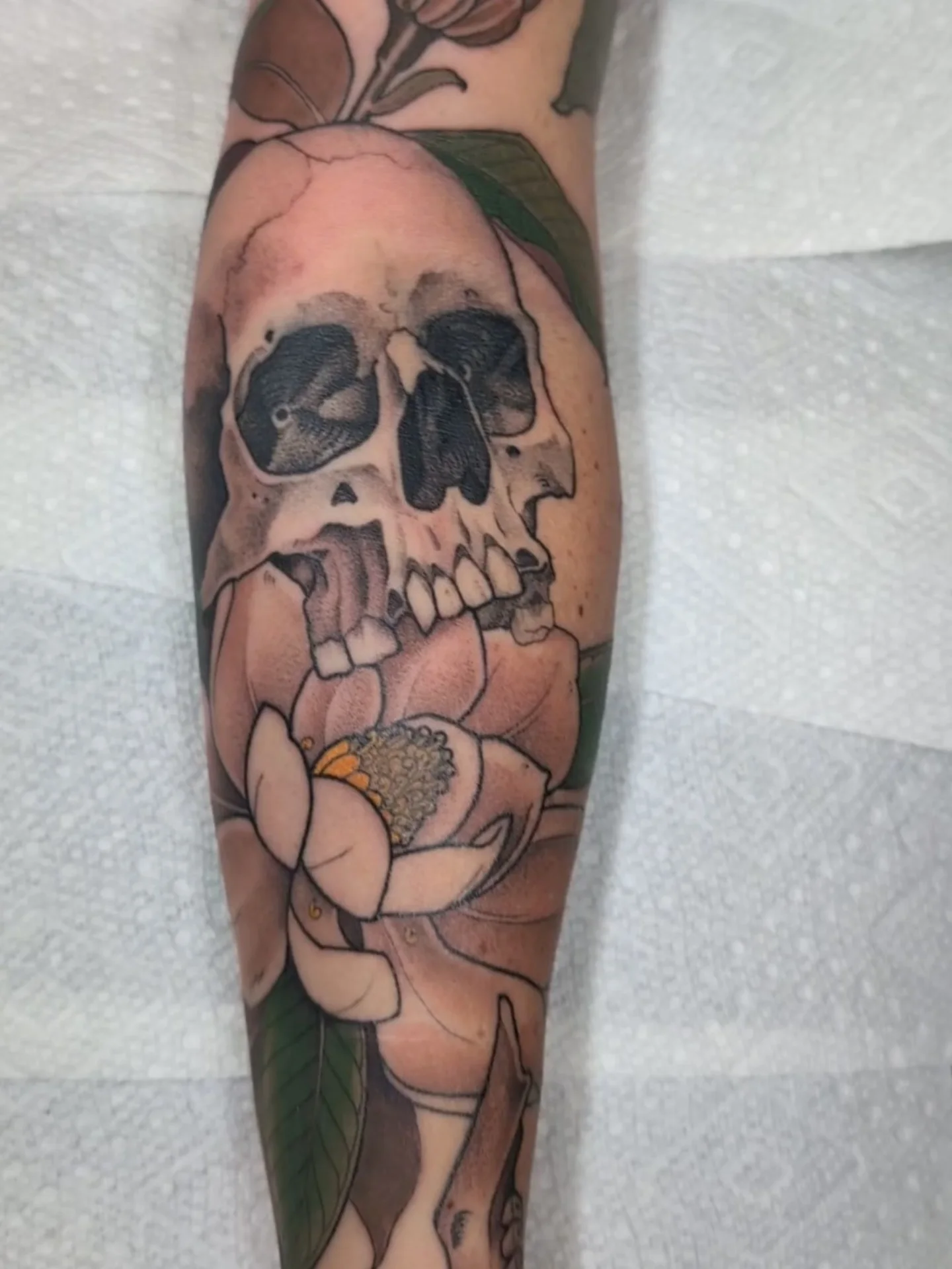Skull and flower realism tattoo on the forearm by English Cousins, Nashville, Tennessee