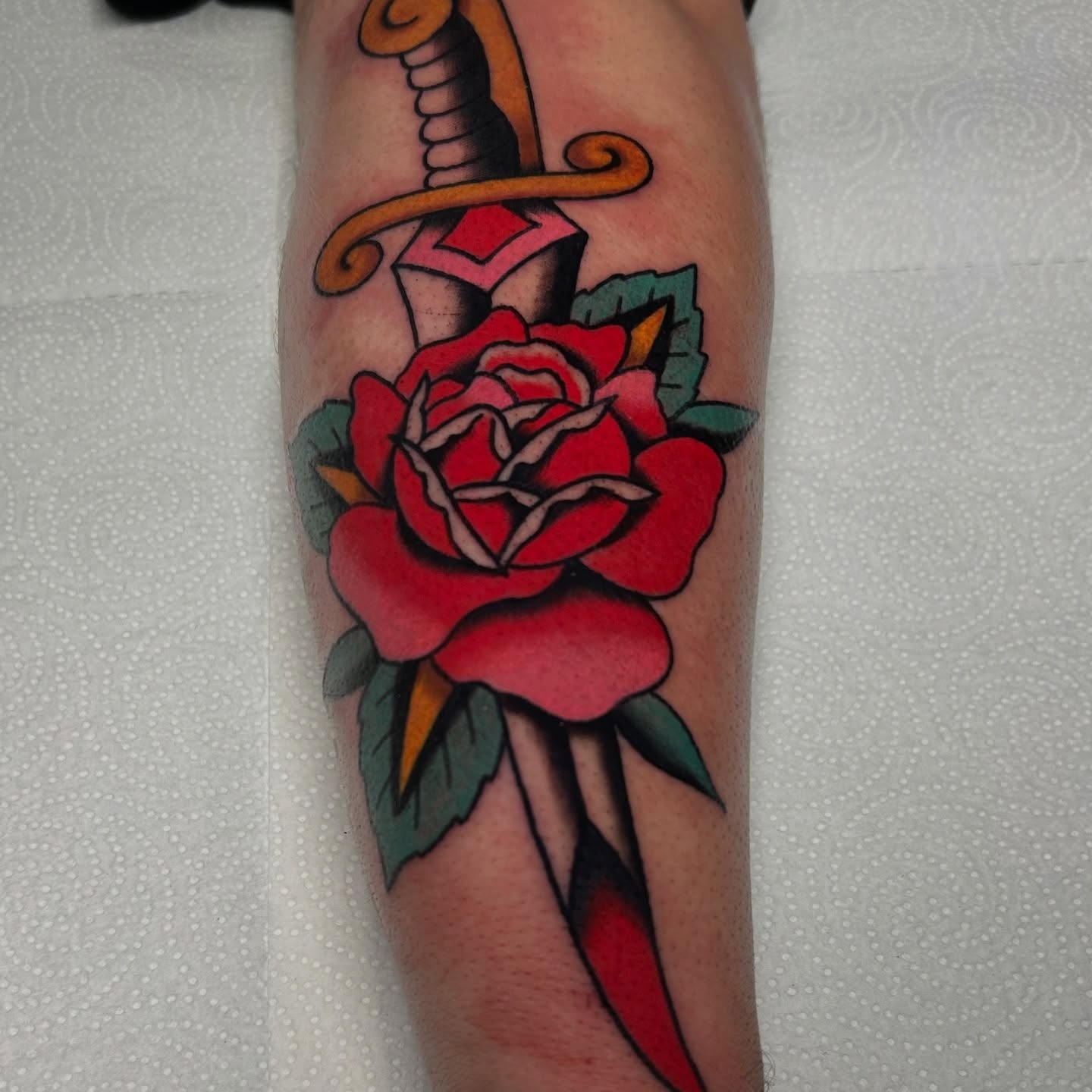 Sword and rose American traditional tattoo on the forearm by Mitch Hoggard