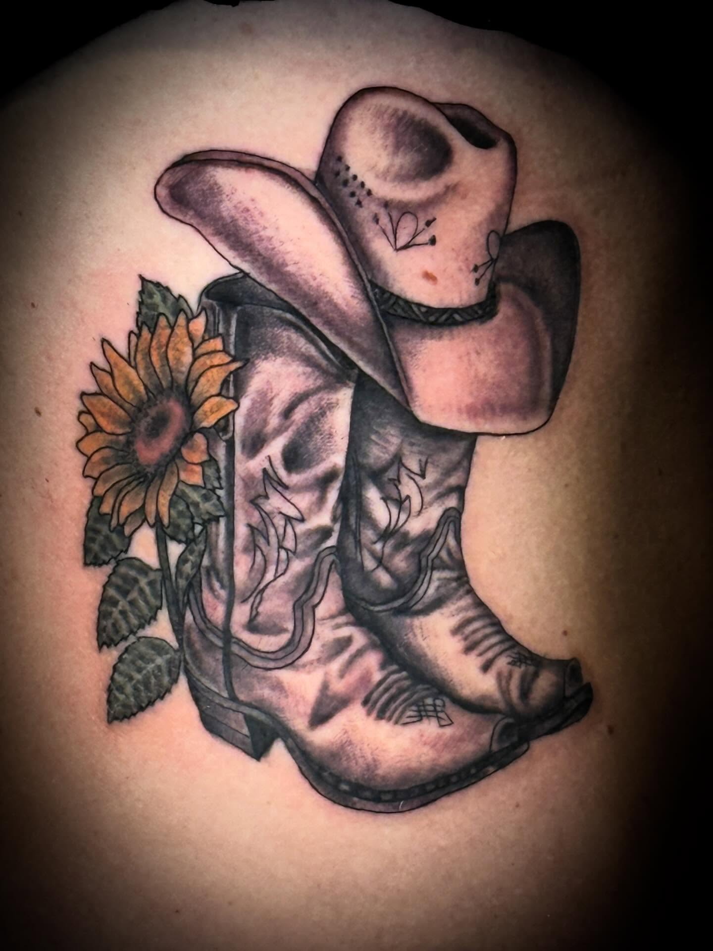 Cowboy boot and hat realism tattoo on the shoulder by Suzanne B