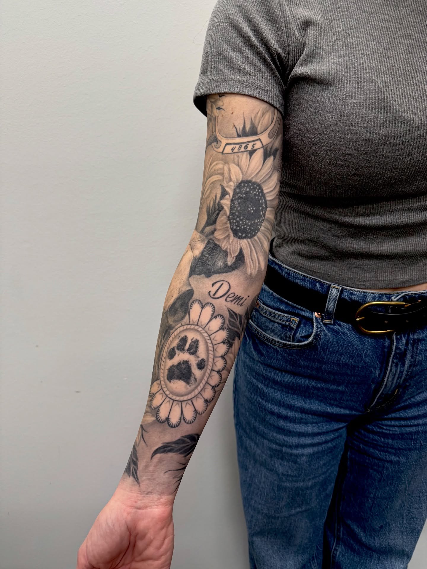 Sunflower and paw print dotwork tattoo on the forearm by Sam Oakes
