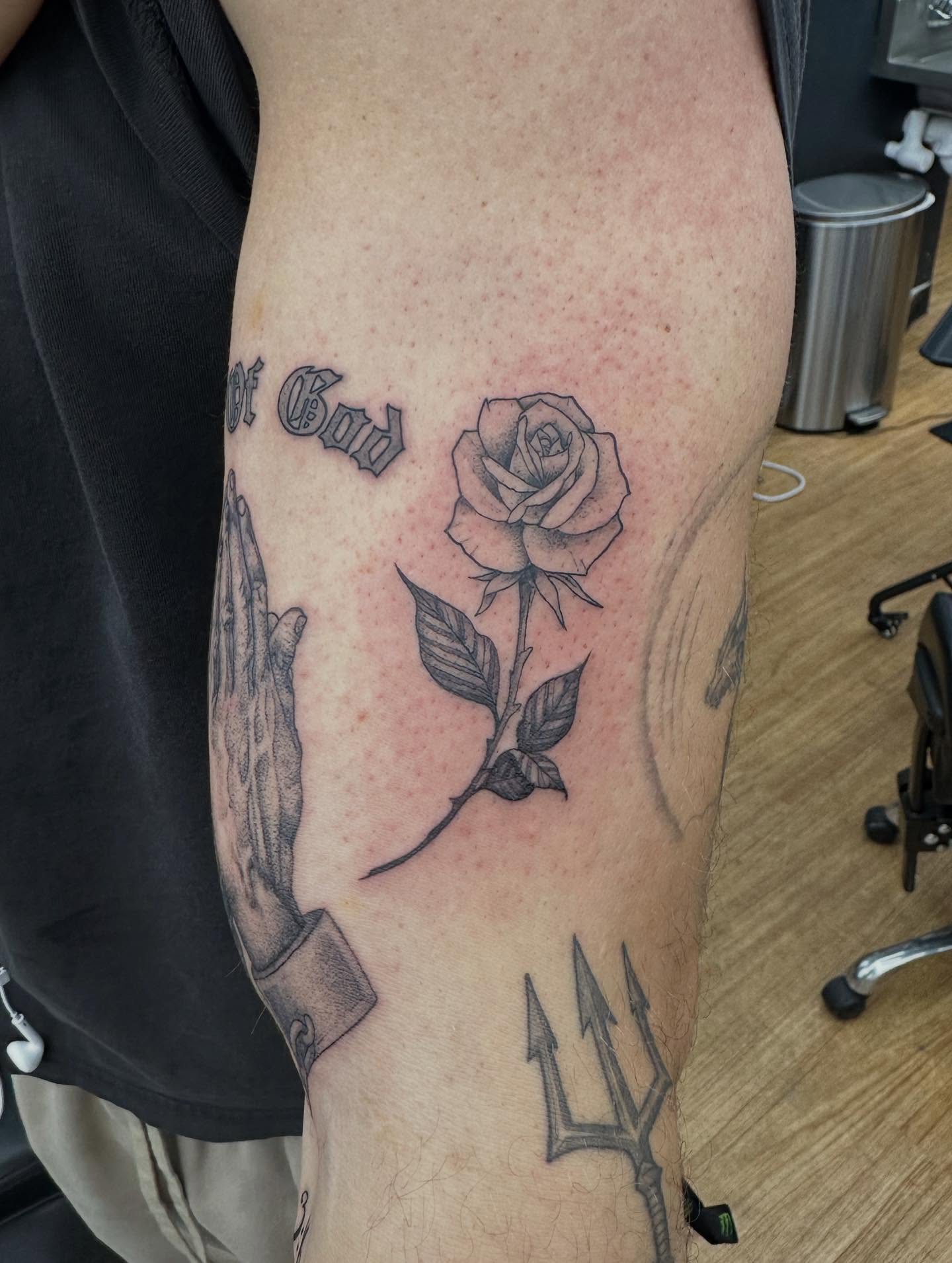 Praying hands and rose black and grey tattoo on the forearm by Jack