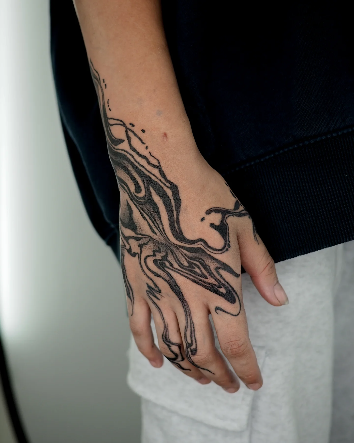 Abstract fluid dotwork tattoo on the hand by MK