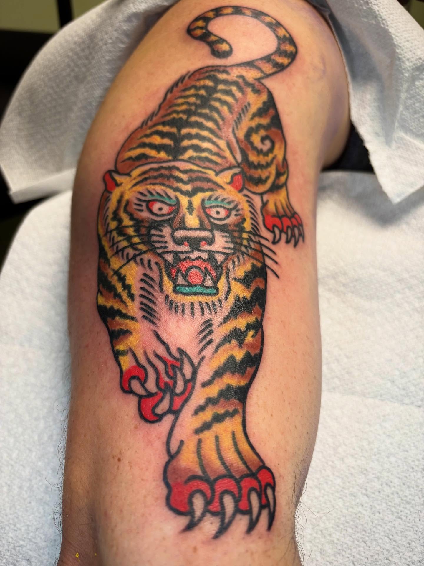 Tiger American traditional tattoo on the upper arm by 🌹