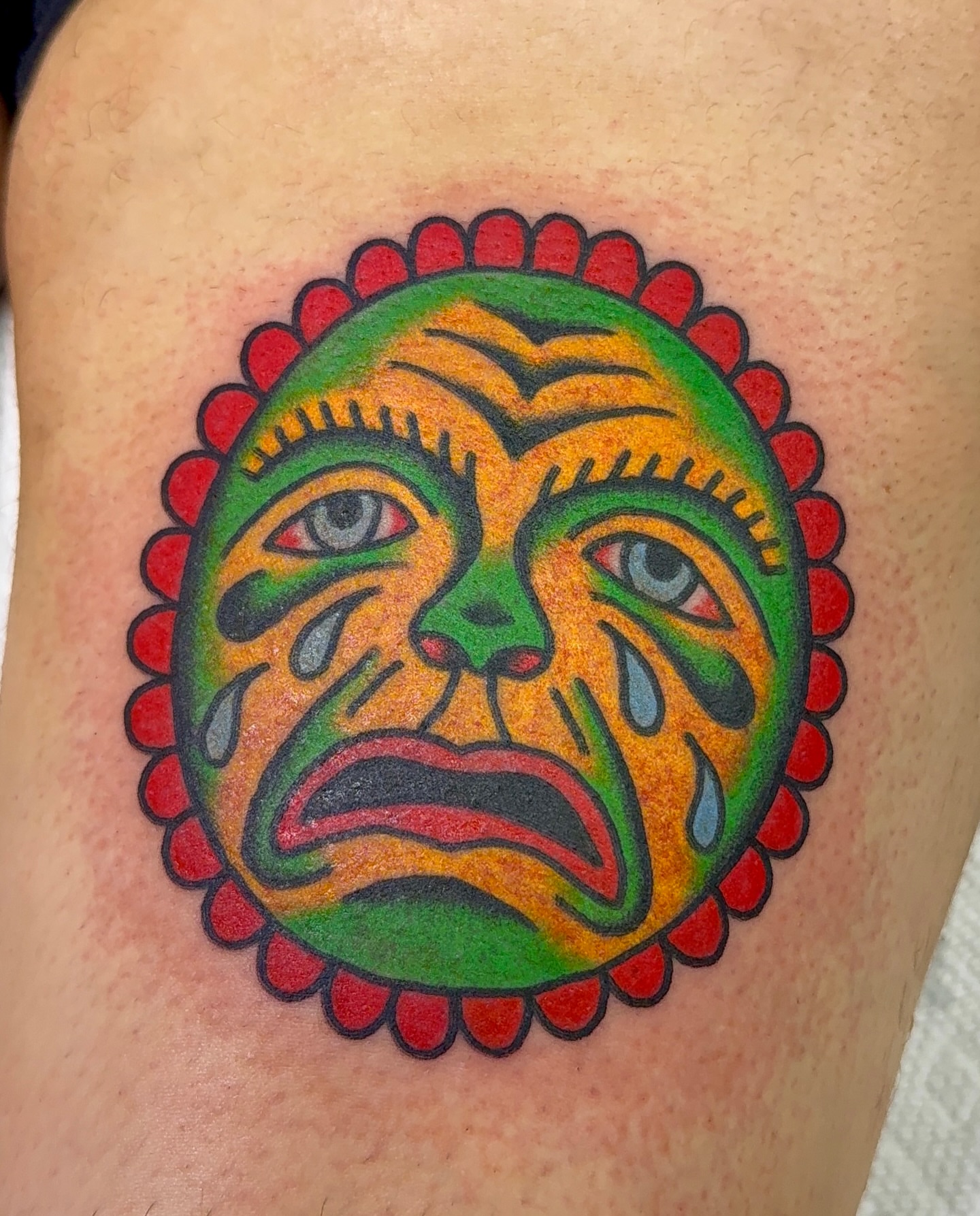 Sad mask American traditional tattoo on the thigh by VAY