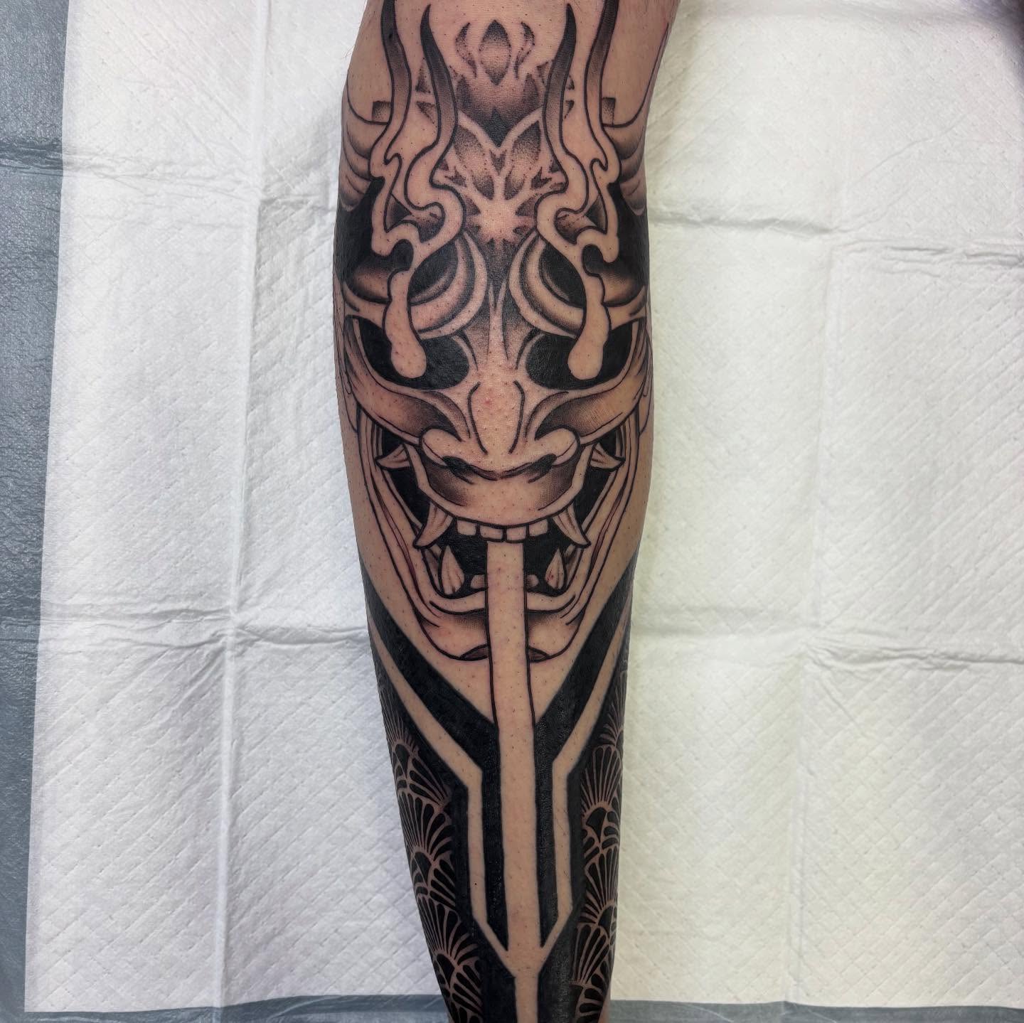 Mask and sword geometric tattoo on the forearm by Amy Kolton