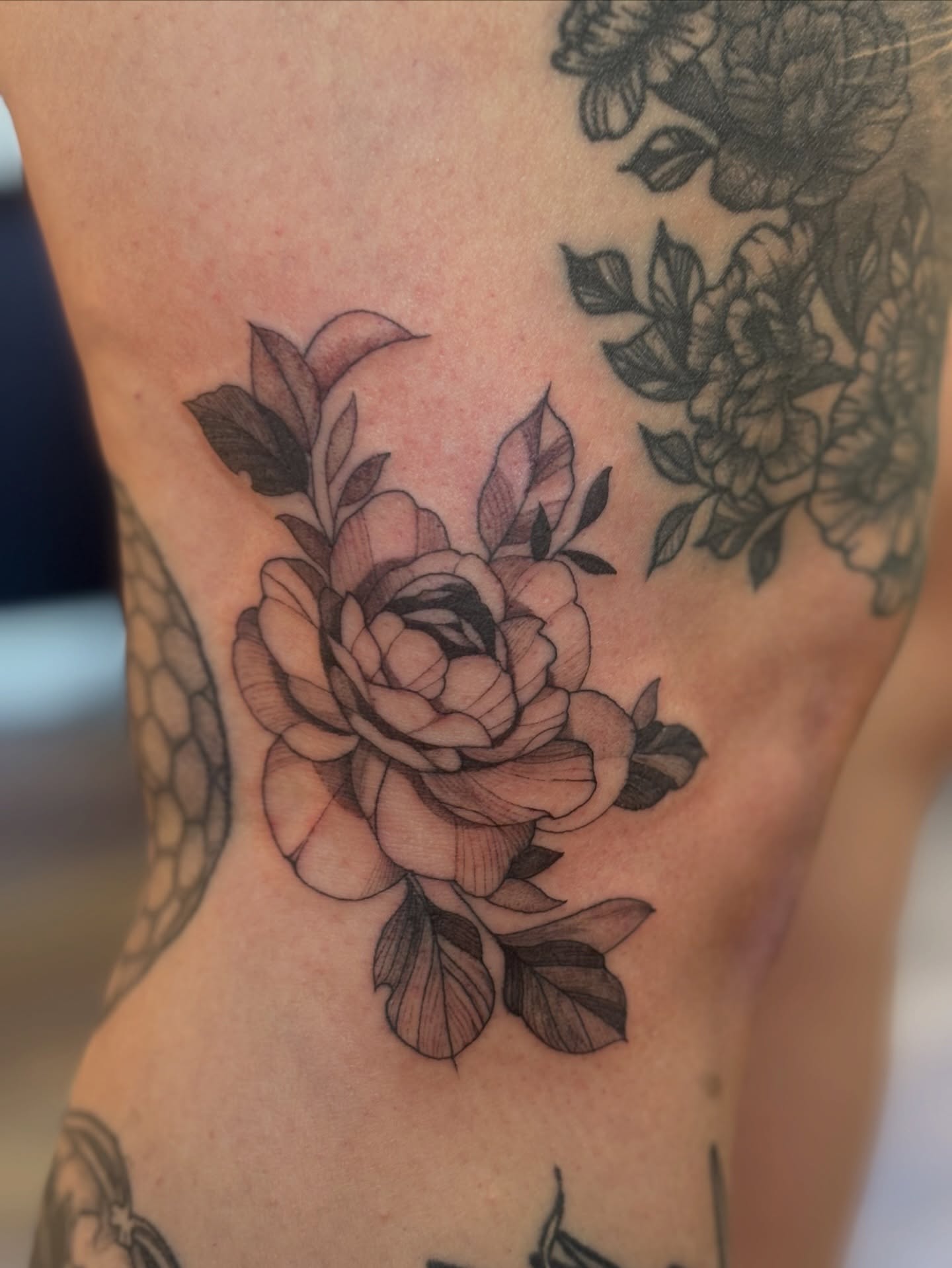 Peony black and grey tattoo on the ribs by MJ Saunders