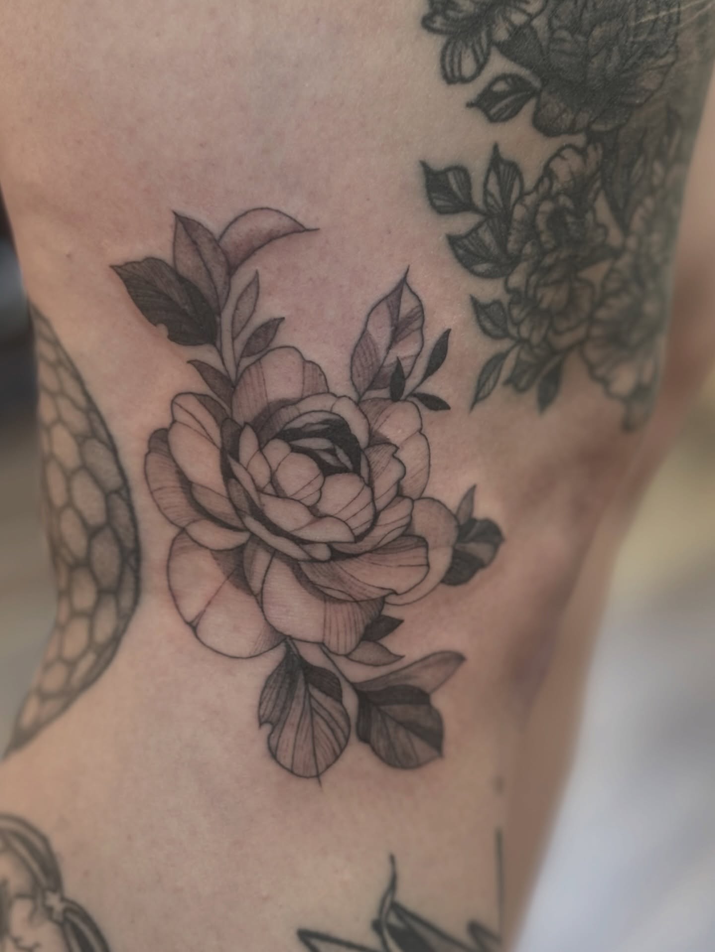 Peony black and grey tattoo on the thigh by MJ Saunders