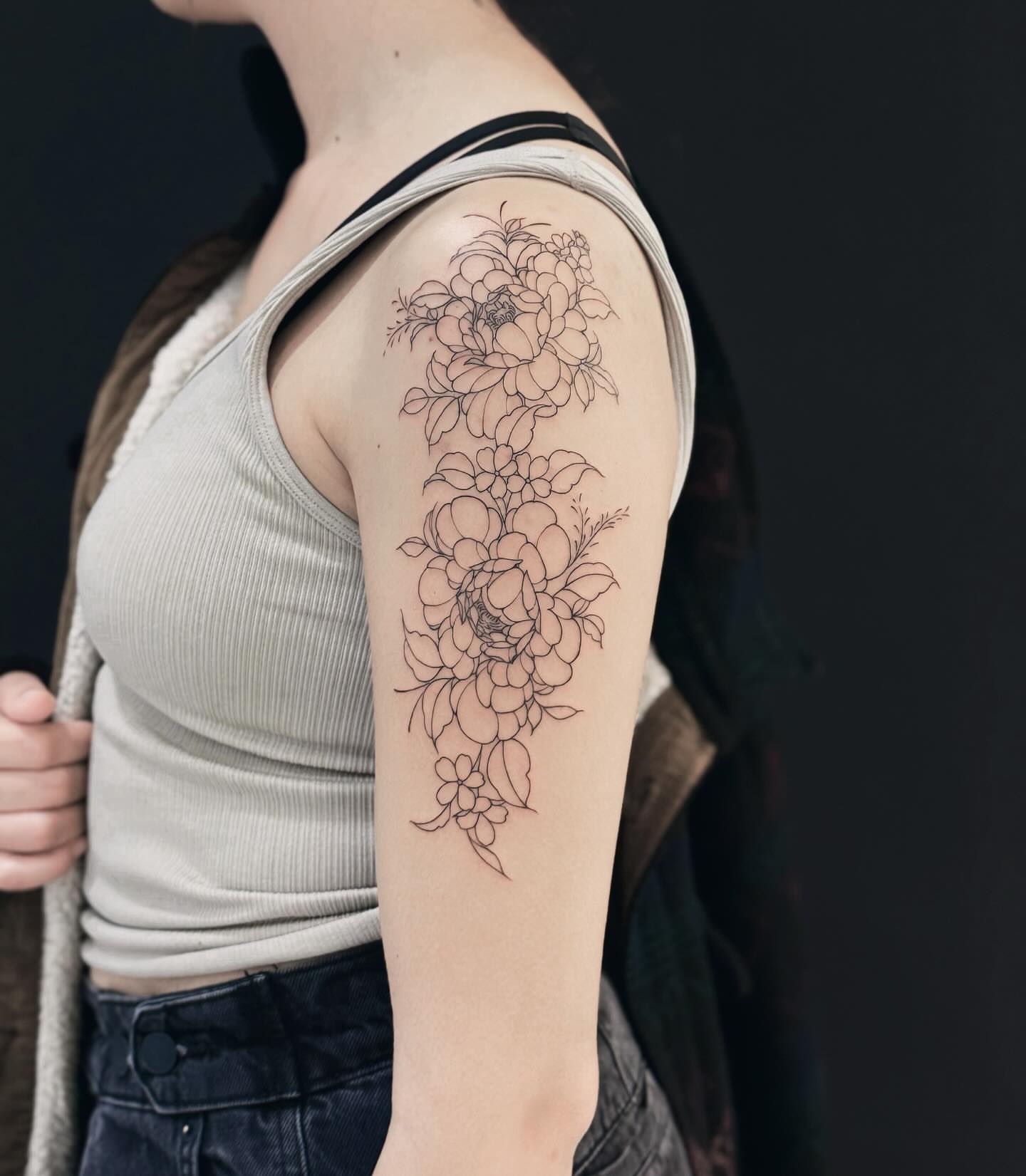 Floral arrangement black and grey tattoo on the upper arm by Raytattooist