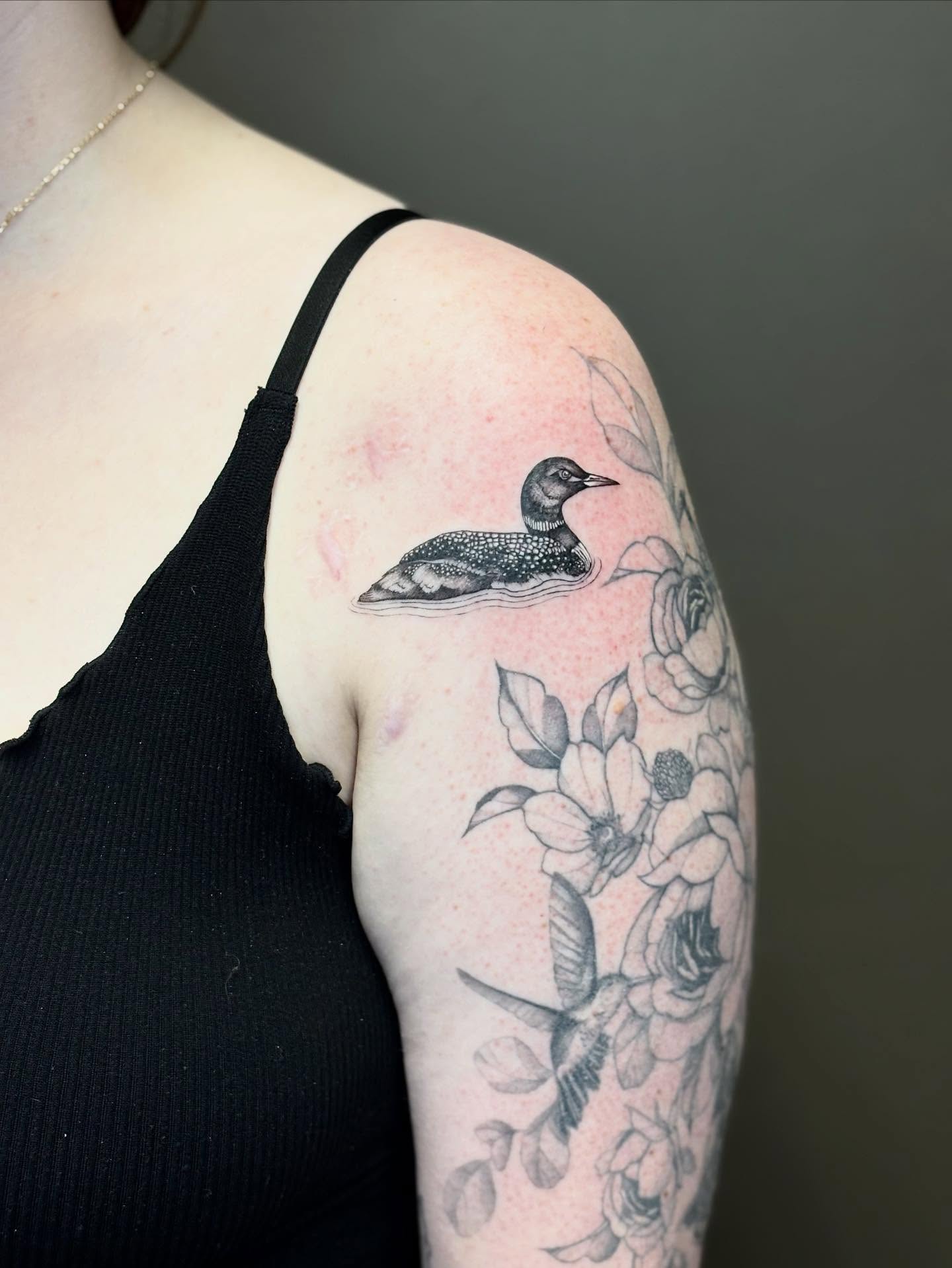 Loon and floral black and grey tattoo on the upper arm by 🖤Sidney🖤