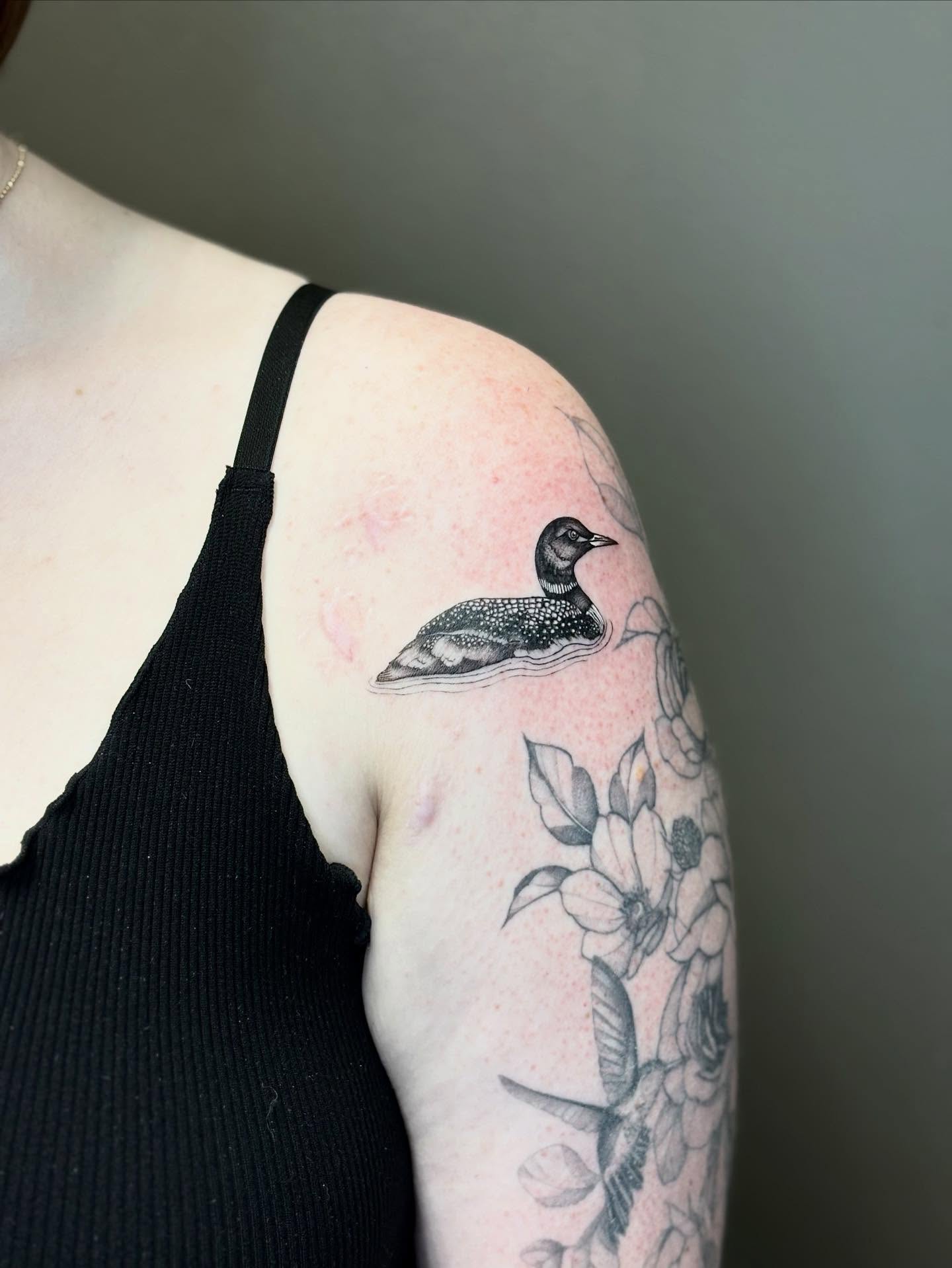 Loon and flowers dotwork tattoo on the upper arm by 🖤Sidney🖤