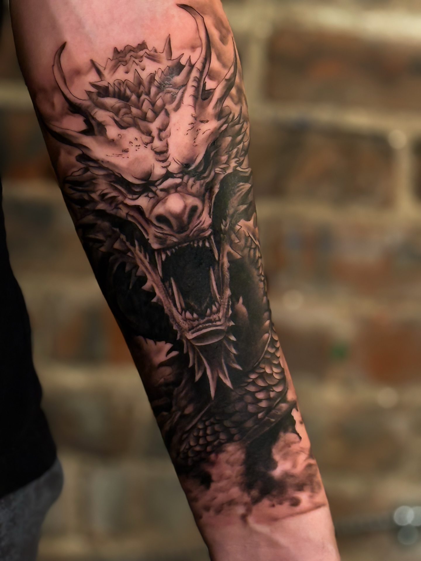 Dragon realism tattoo on the forearm by Iryna Polyakhova