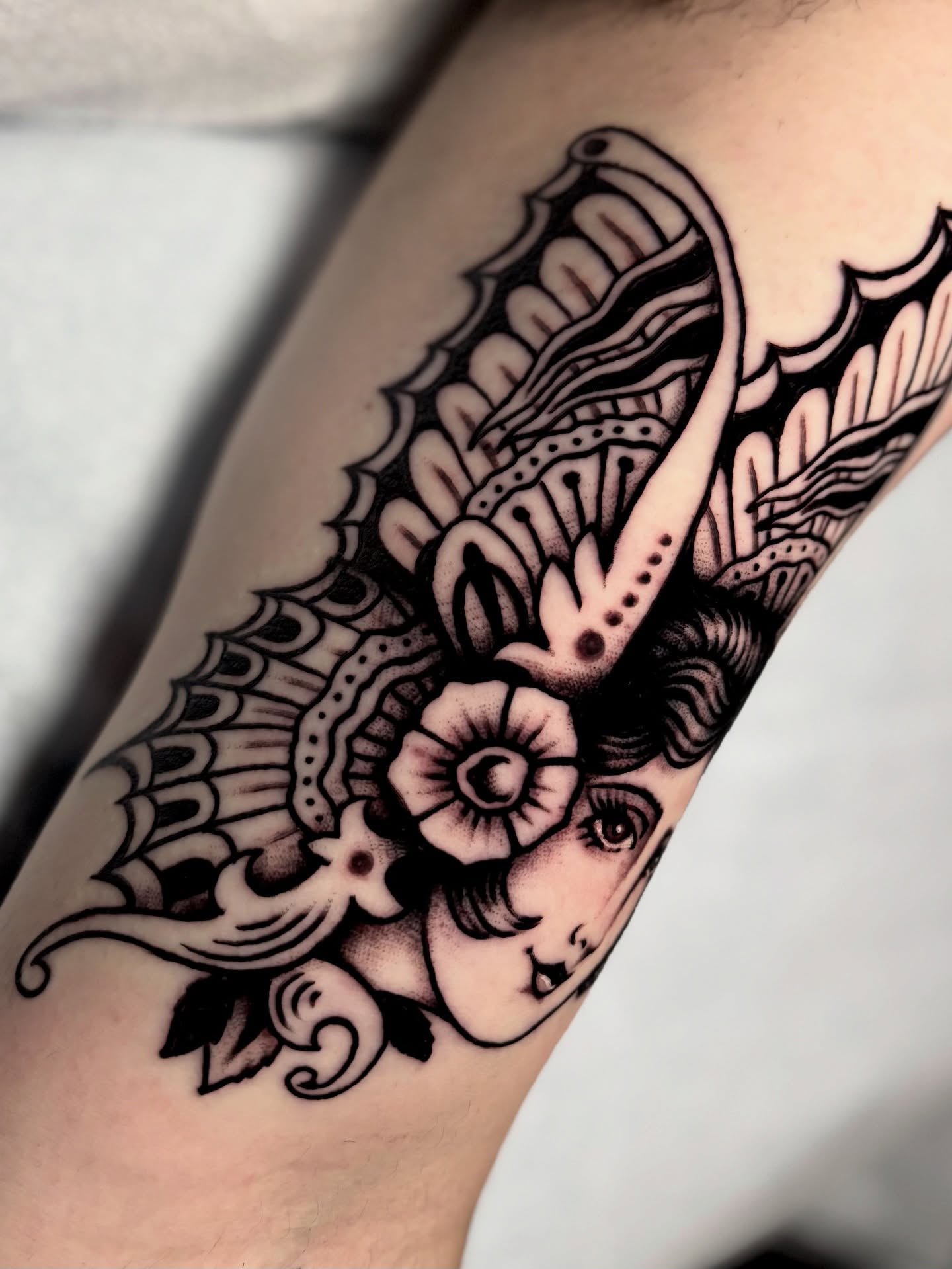 Woman's face with floral elements American traditional tattoo on the forearm by Weston Imhoff