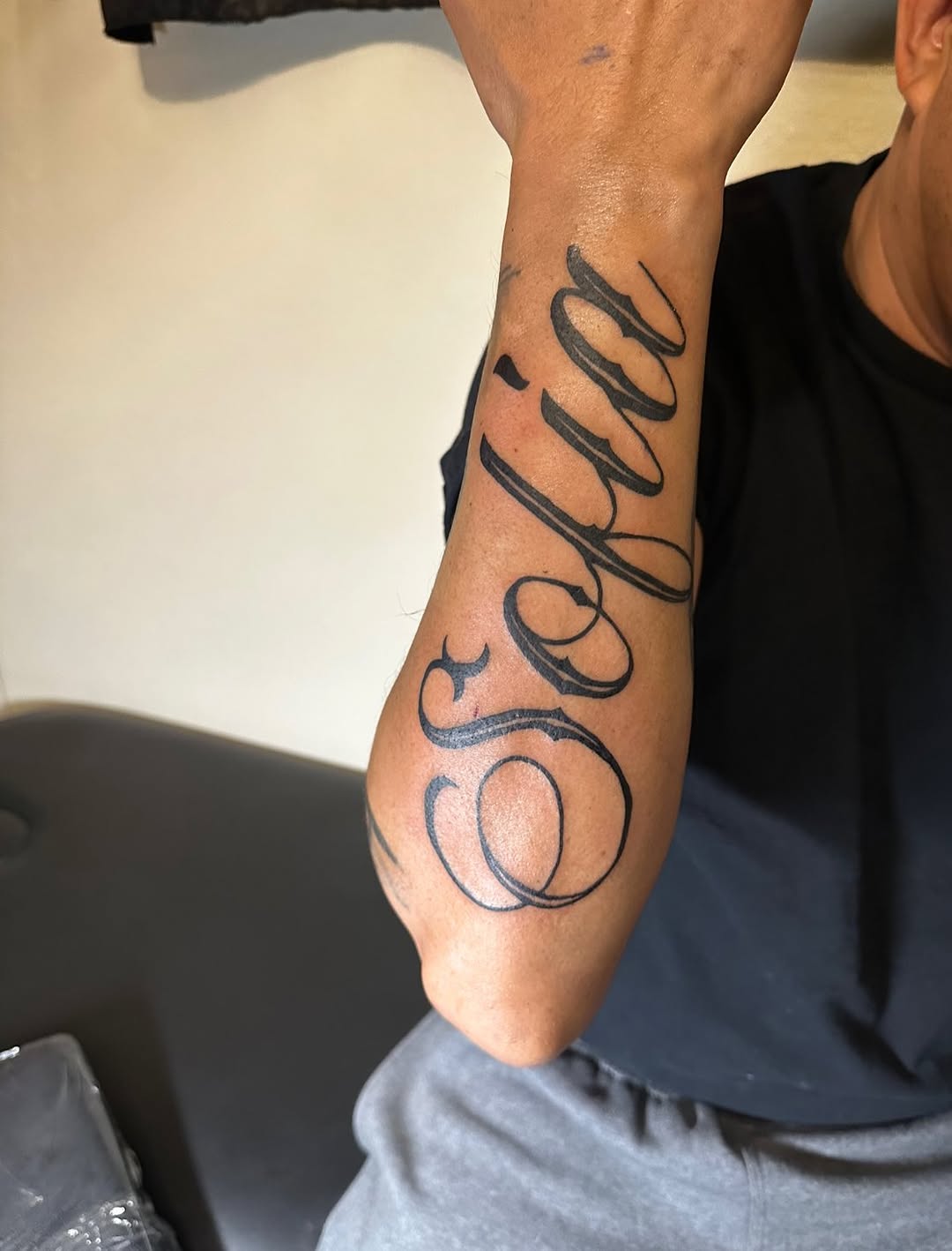 Script lettering lettering tattoo on the forearm by Lupita Ink