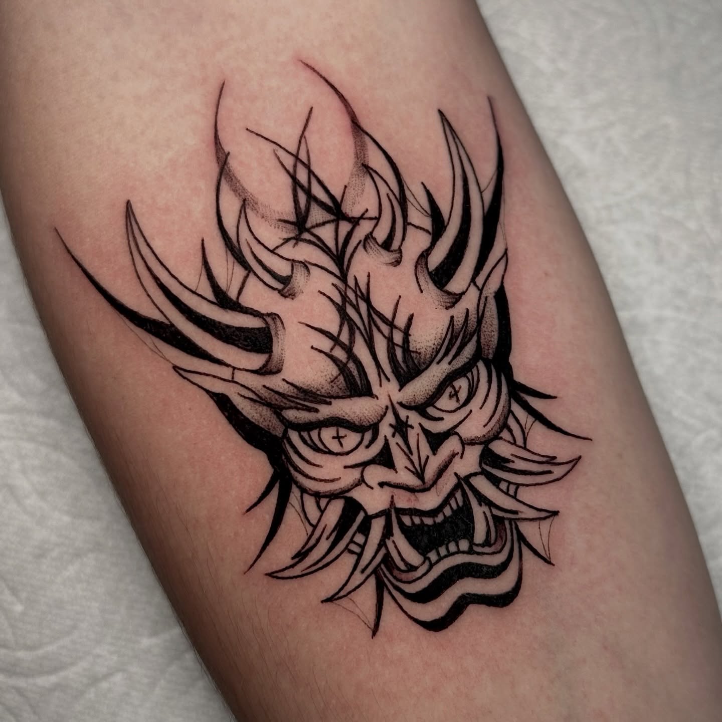 Demon mask black and grey tattoo on the forearm by Crystal, Las Vegas, Nevada