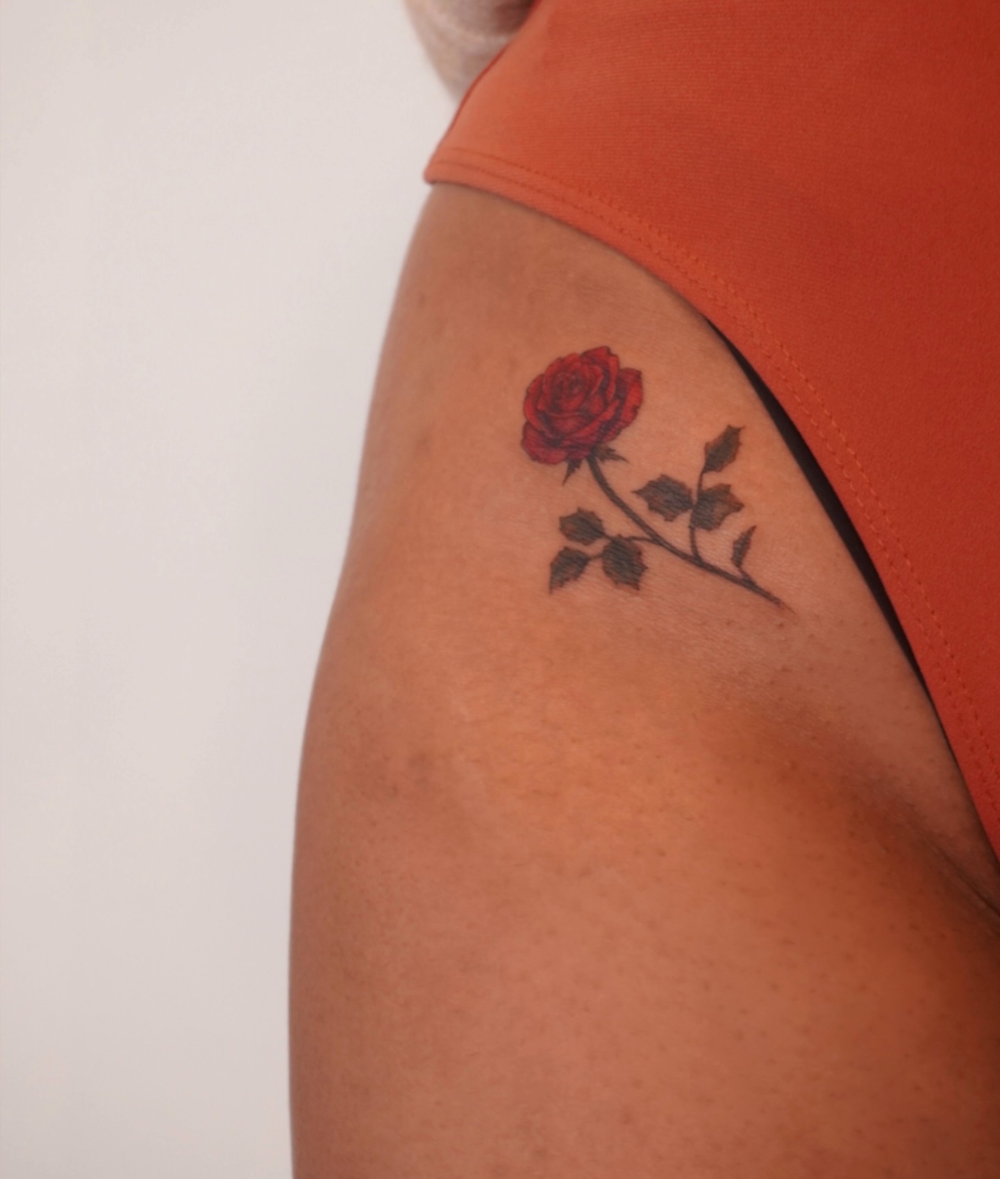 Red rose realism tattoo on the upper arm by Sun Child Tattoo 🌻