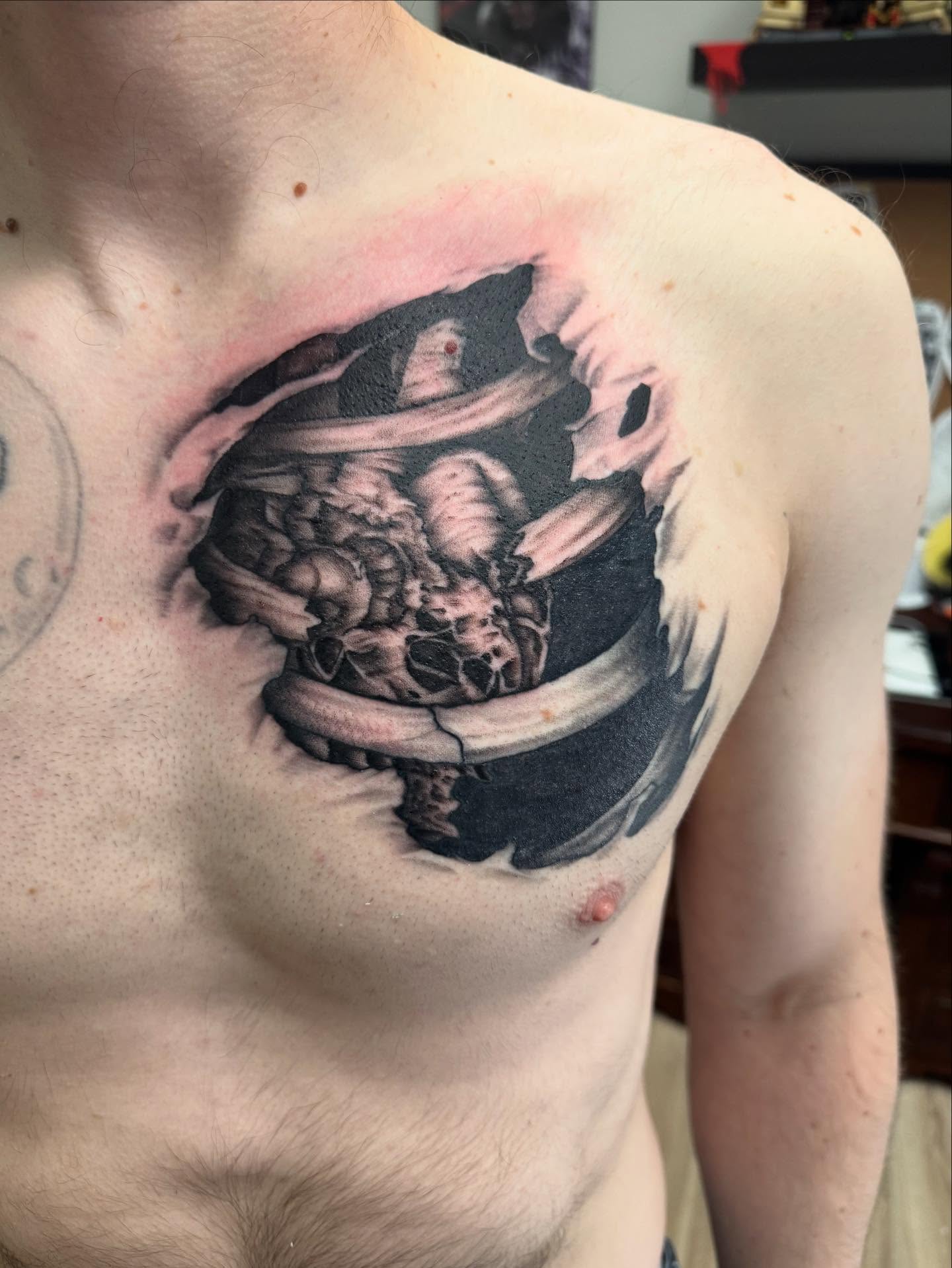 Astronaut inside a space suit realism tattoo on the chest by Jon Fleming