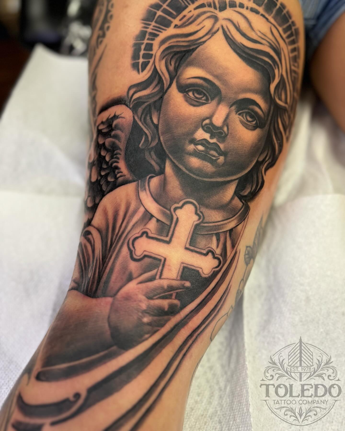 Child with cross realism tattoo on the forearm by Kodi Klo