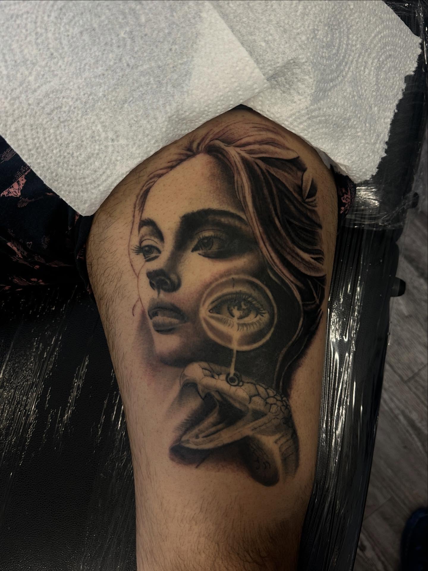 Woman with magnifying glass realism tattoo on the thigh by Matt Kearney
