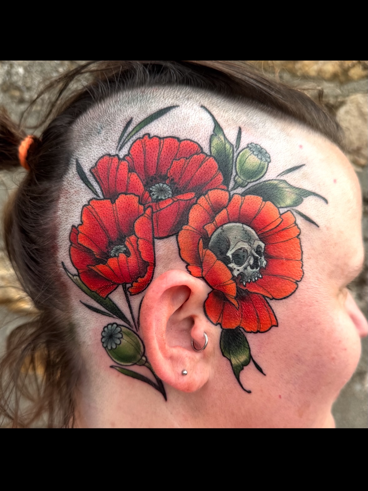 Red poppies and skull American traditional tattoo on the head by Erin Bratzler