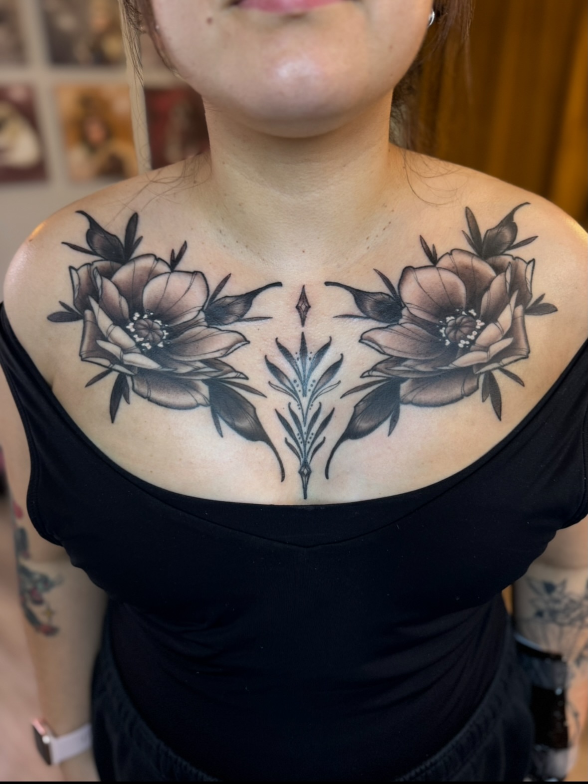 Floral arrangement black and grey tattoo on the chest by Erin Bratzler