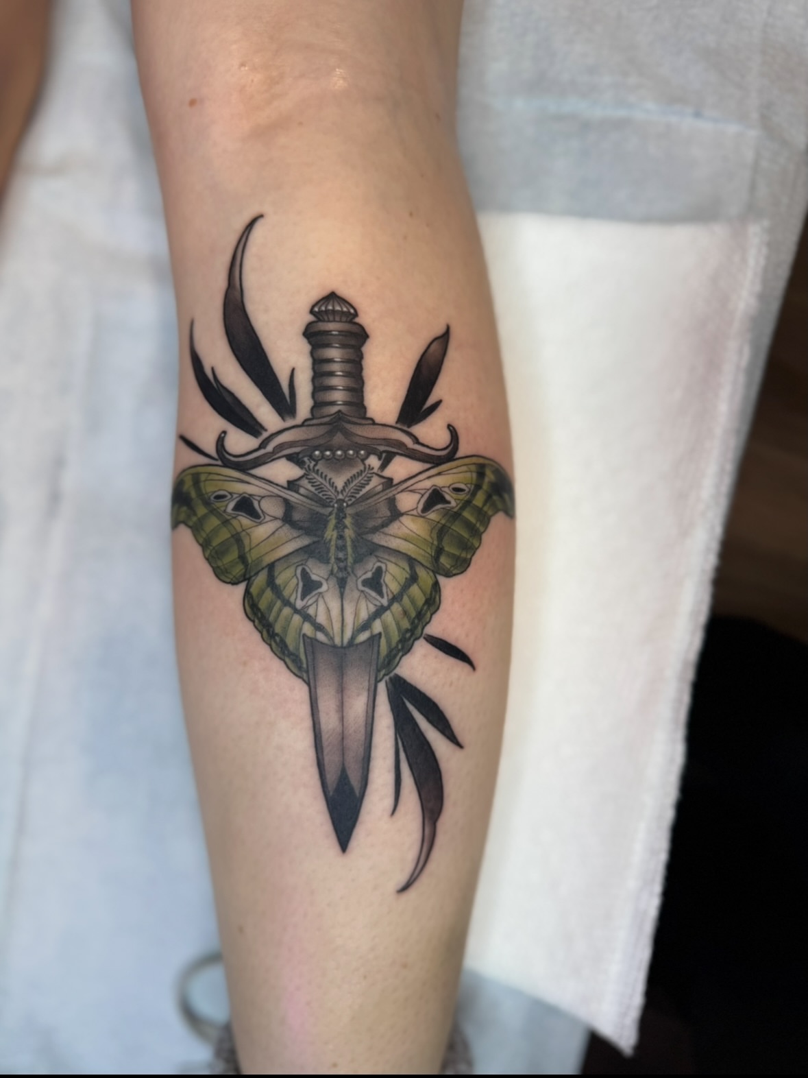 Butterfly and dagger black and grey tattoo on the forearm by Erin Bratzler