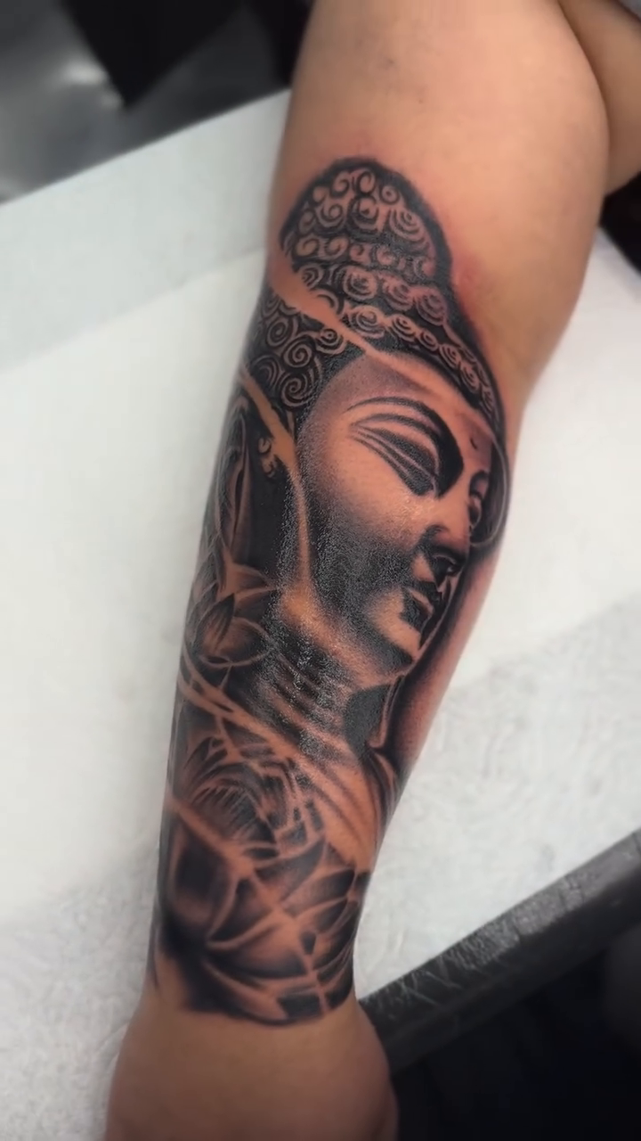 Buddha portrait with floral elements realism tattoo by Alex Romero