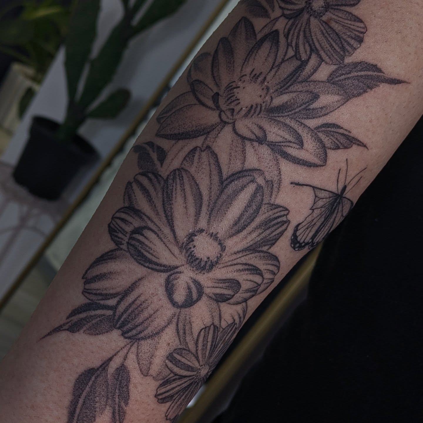 Flowers and butterfly dotwork tattoo on the forearm by Jasmine Dillon