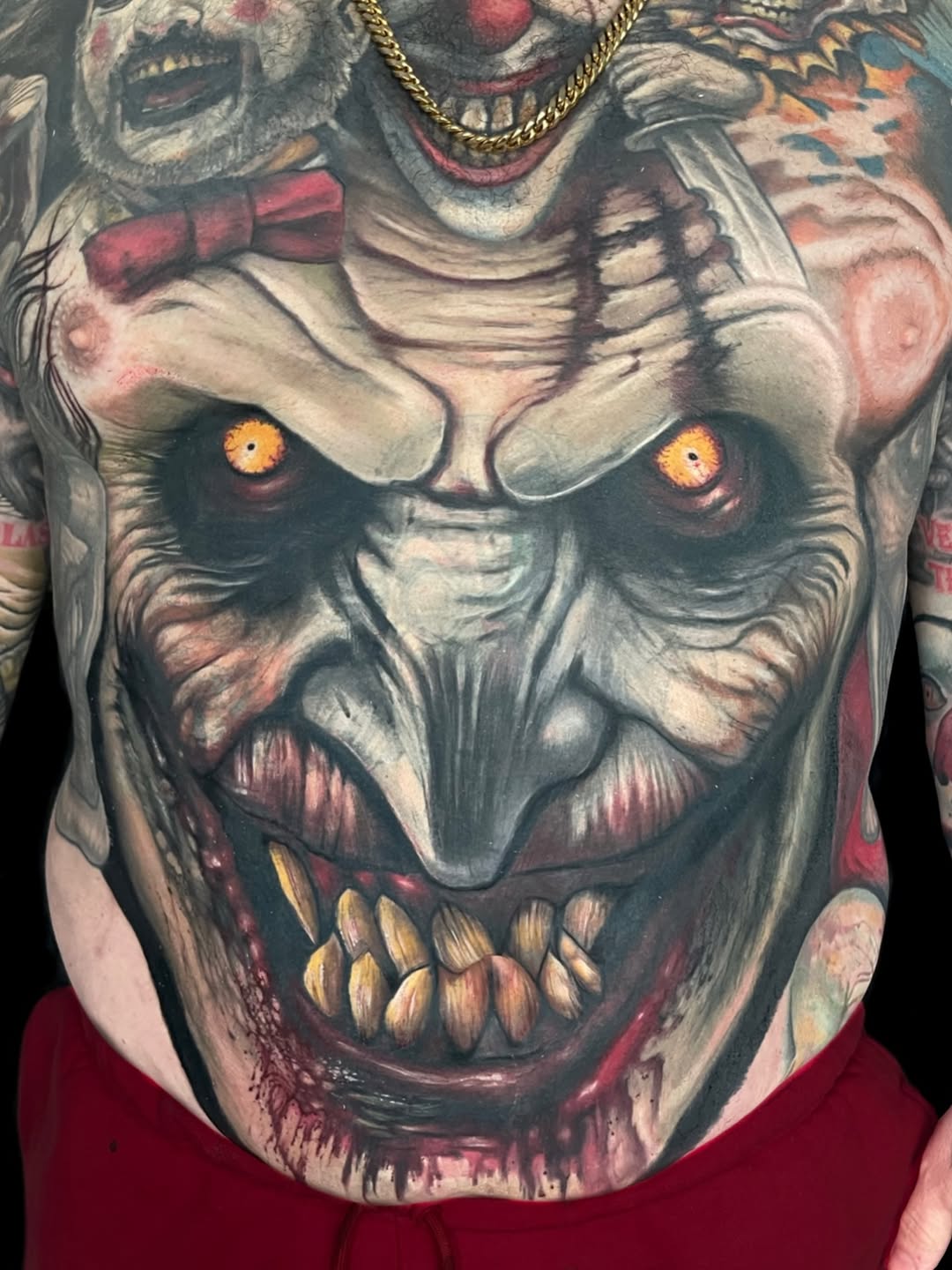 Creepy clown faces realism tattoo on the torso by Rich Bustamante