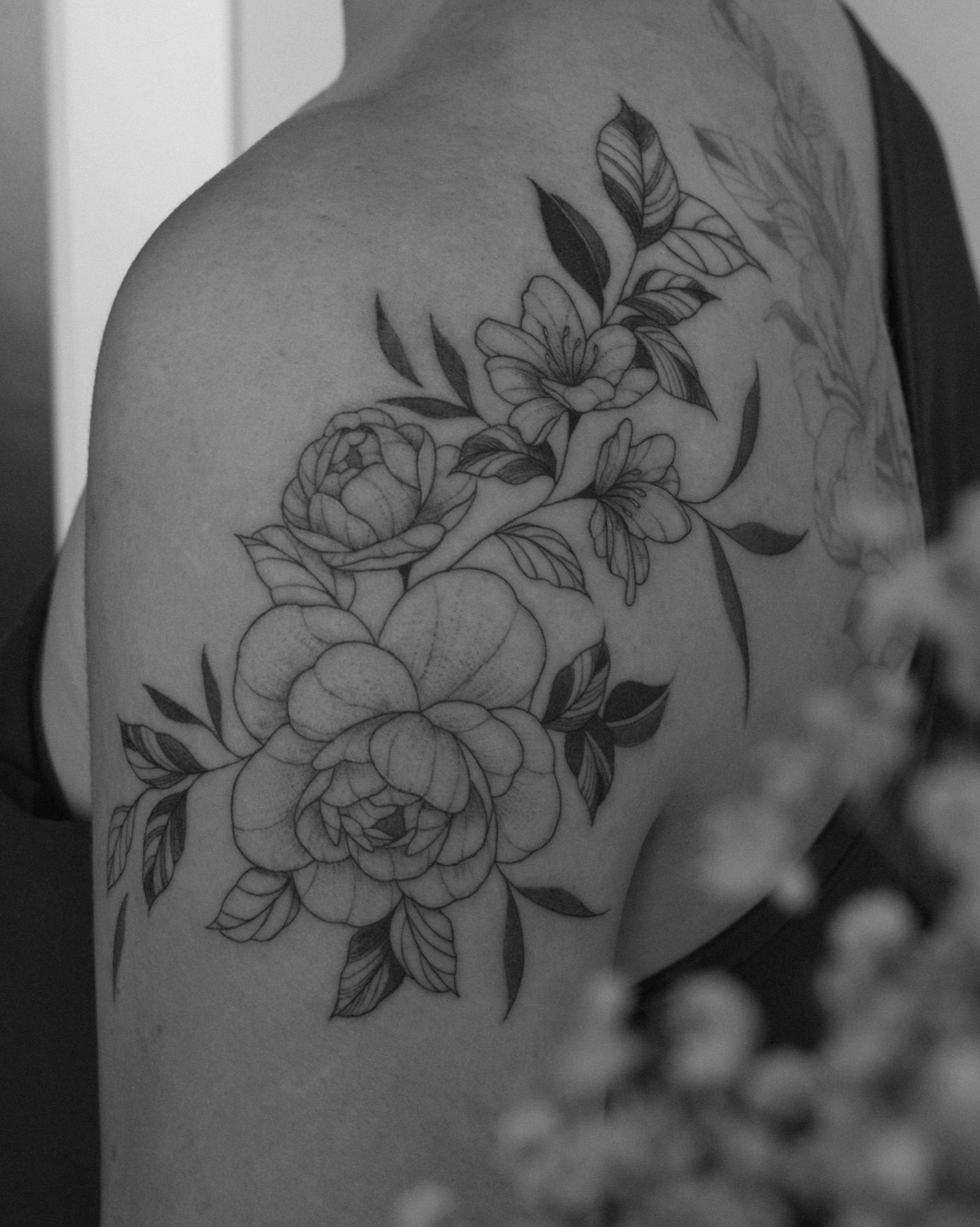 Peonies and leaves black and grey tattoo on the shoulder by Haley Sayers