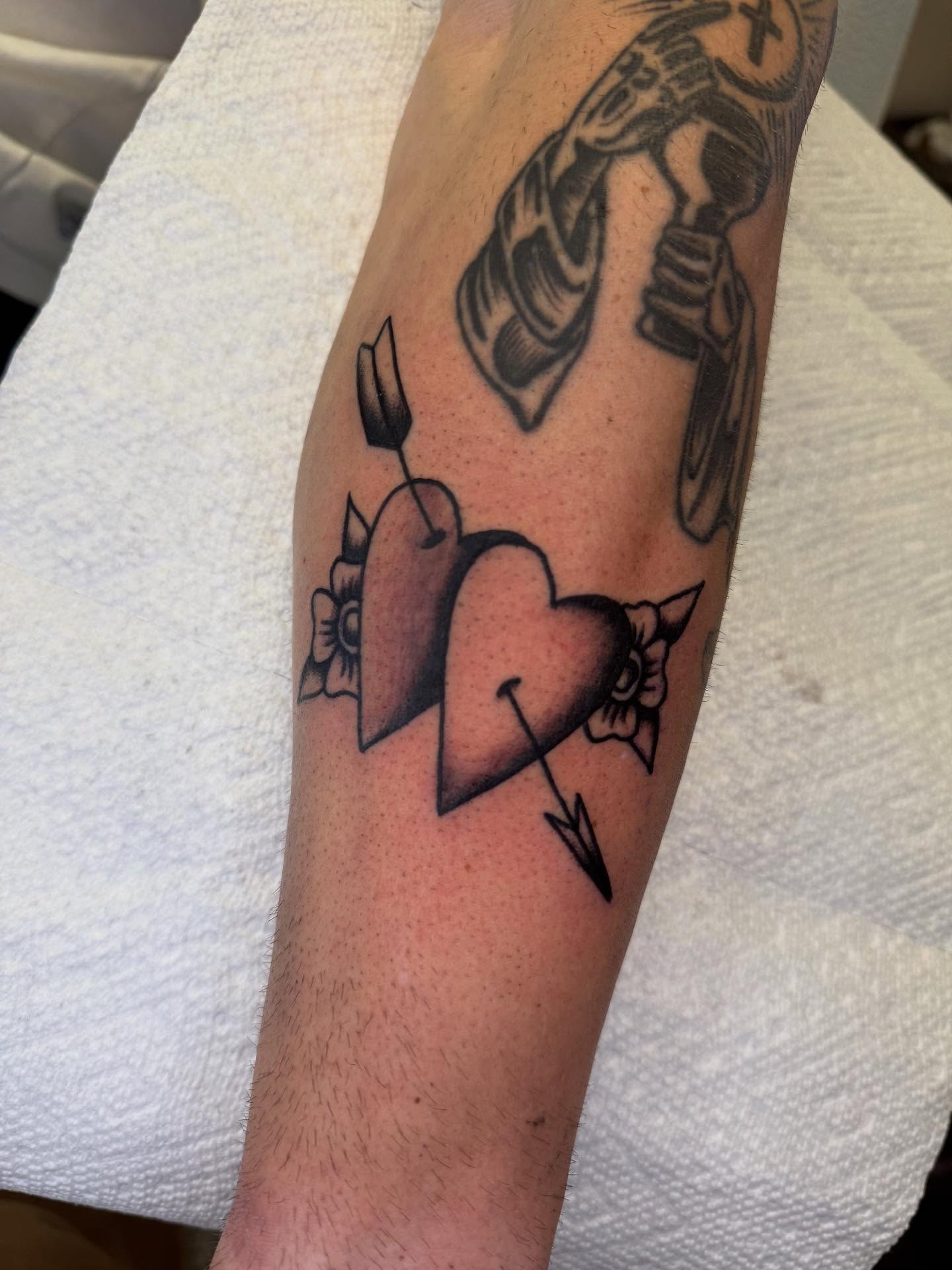 Heart with arrow black and grey tattoo on the forearm by Cody Petkus
