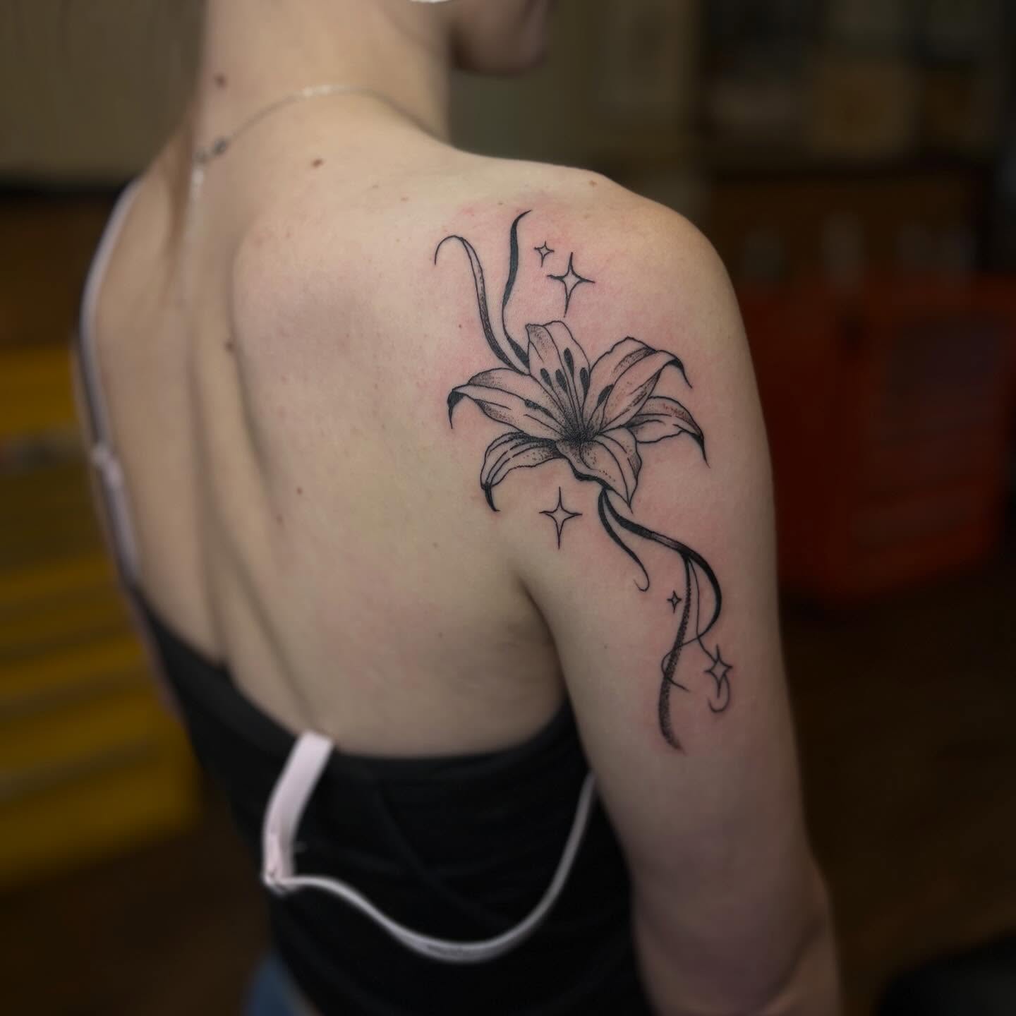 Lily black and grey tattoo on the shoulder by Lauren Deets
