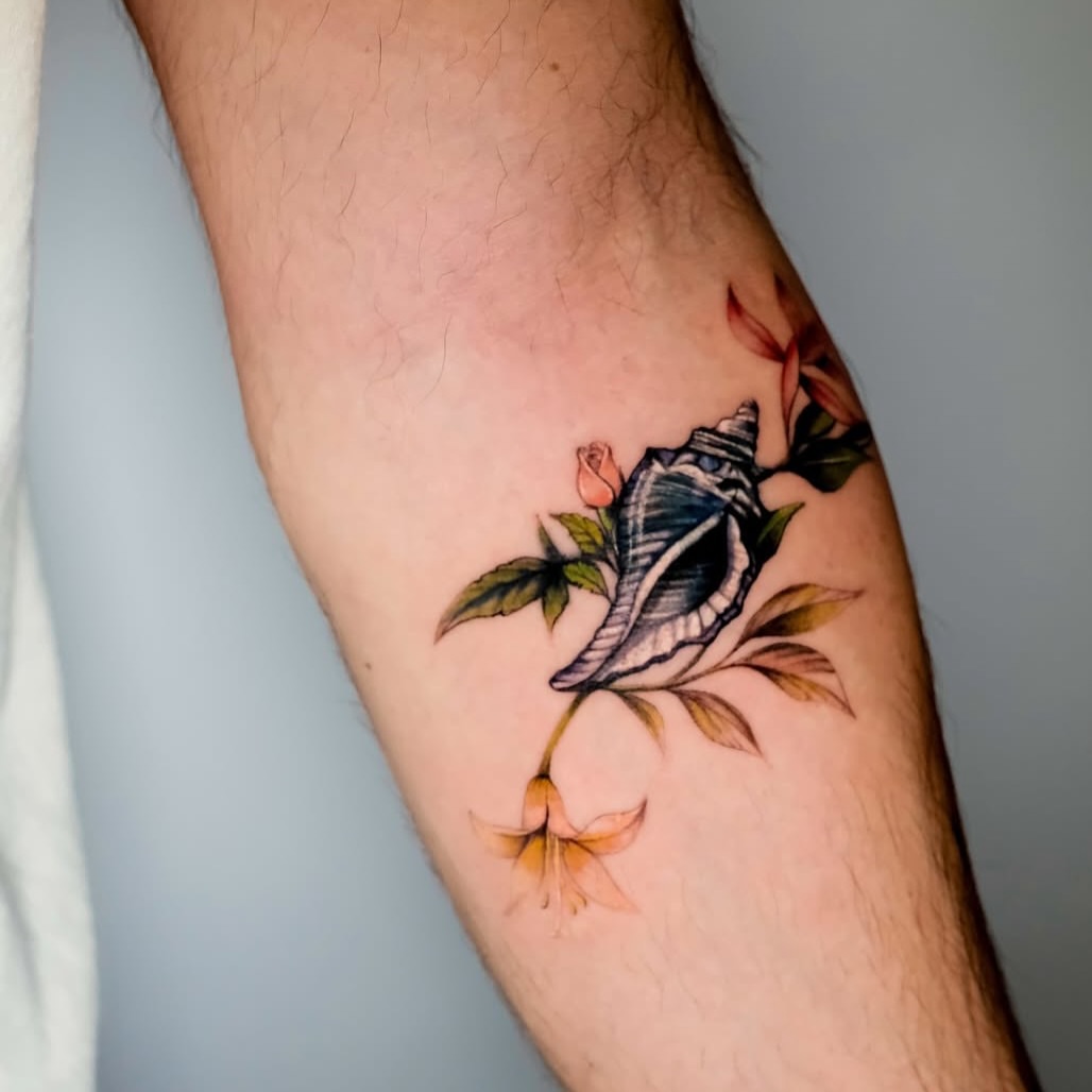 Shell and flowers realism tattoo on the forearm by NAS