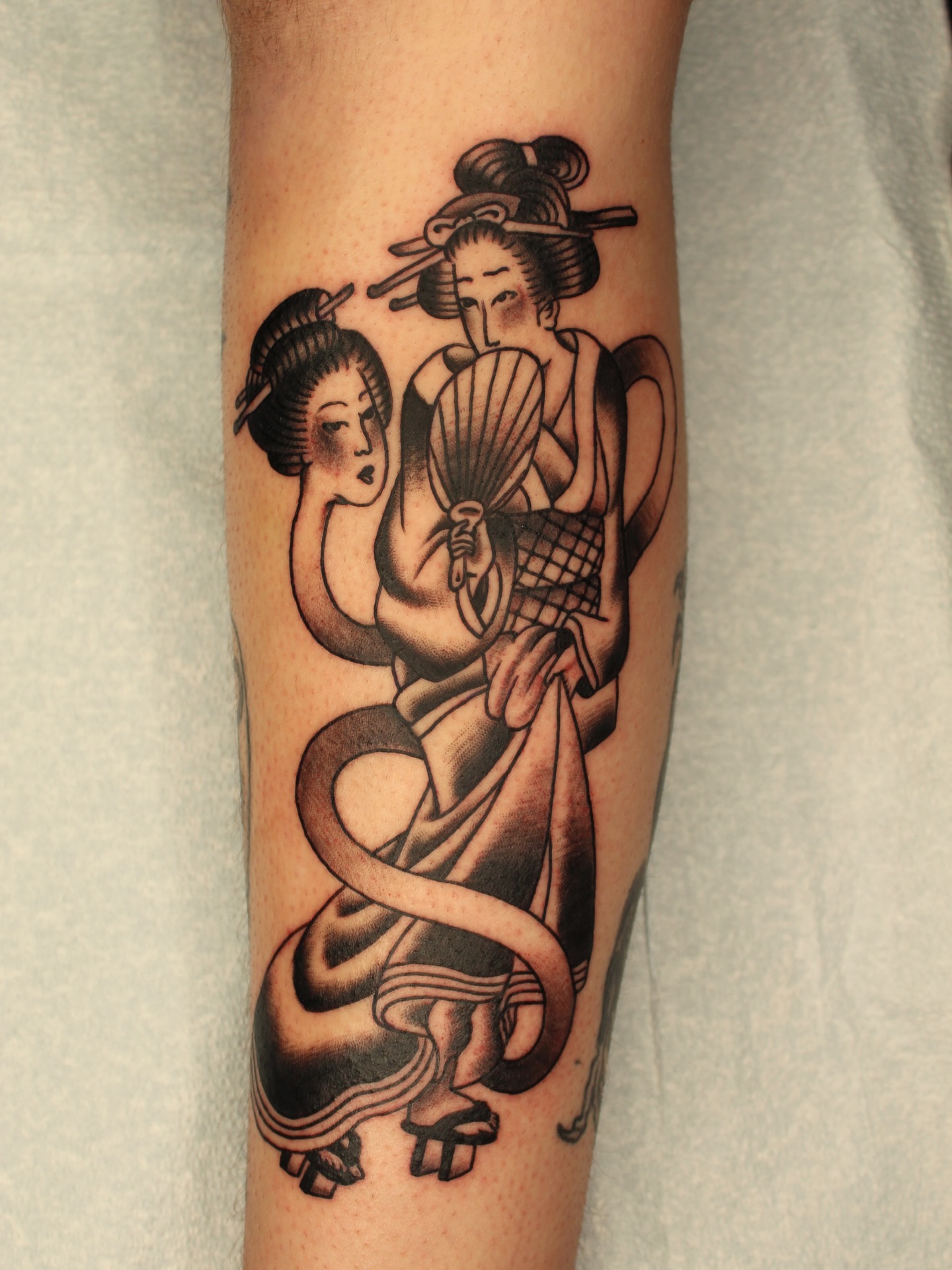 Geisha couple American traditional tattoo on the forearm by Kehrmie Tattoos, Berkeley, California
